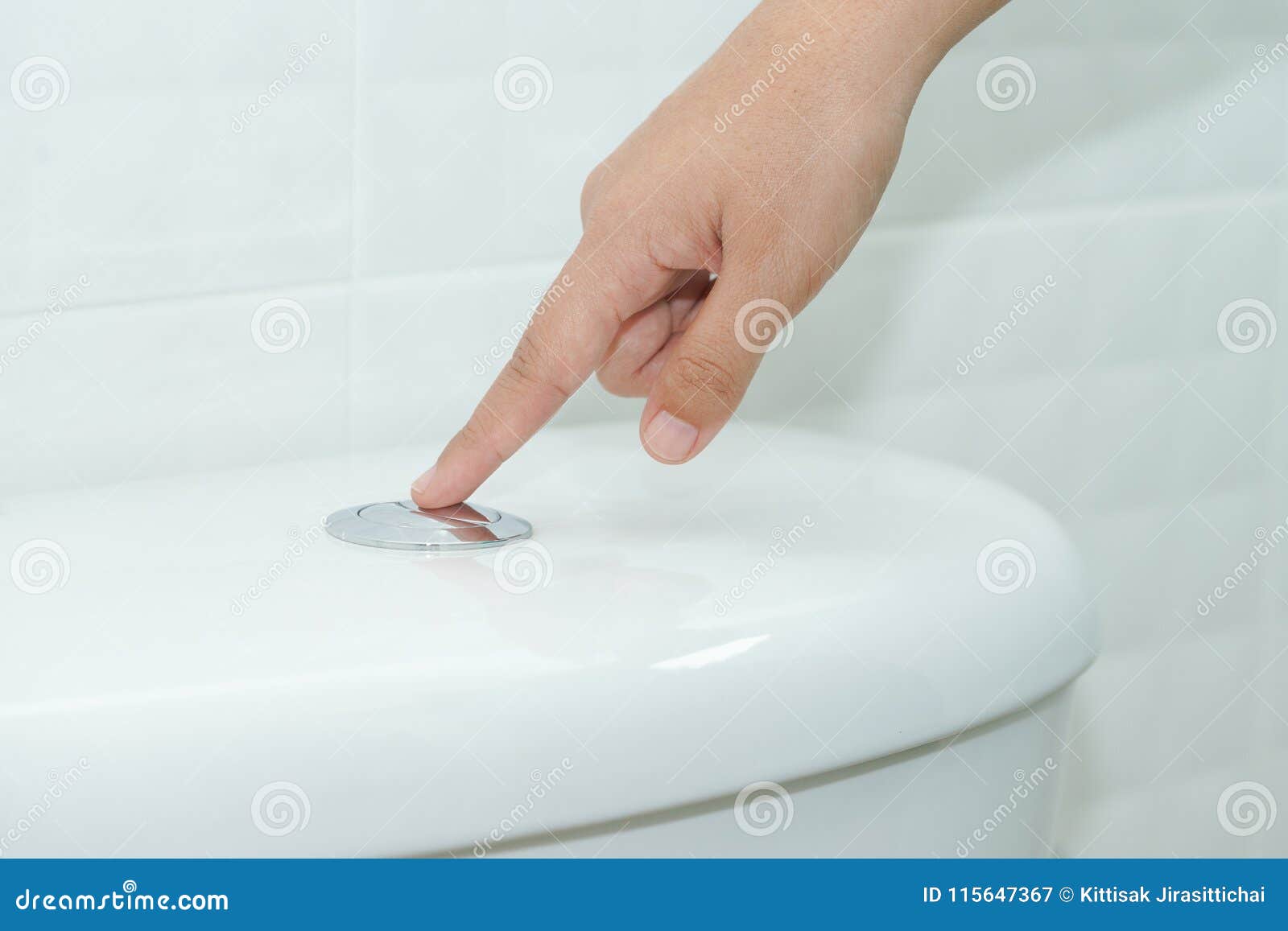 close up of finger pushing a flush toilet button for cleaning. -