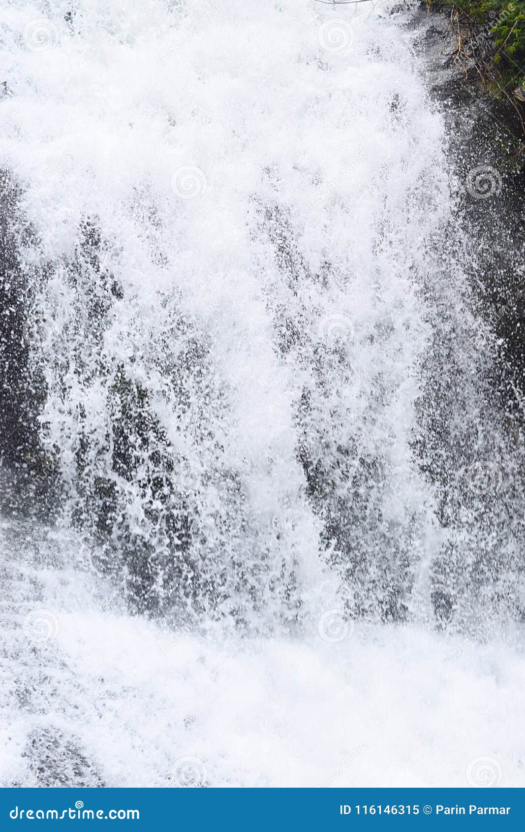 close up of forceful flow of water with sprinkling of white drops