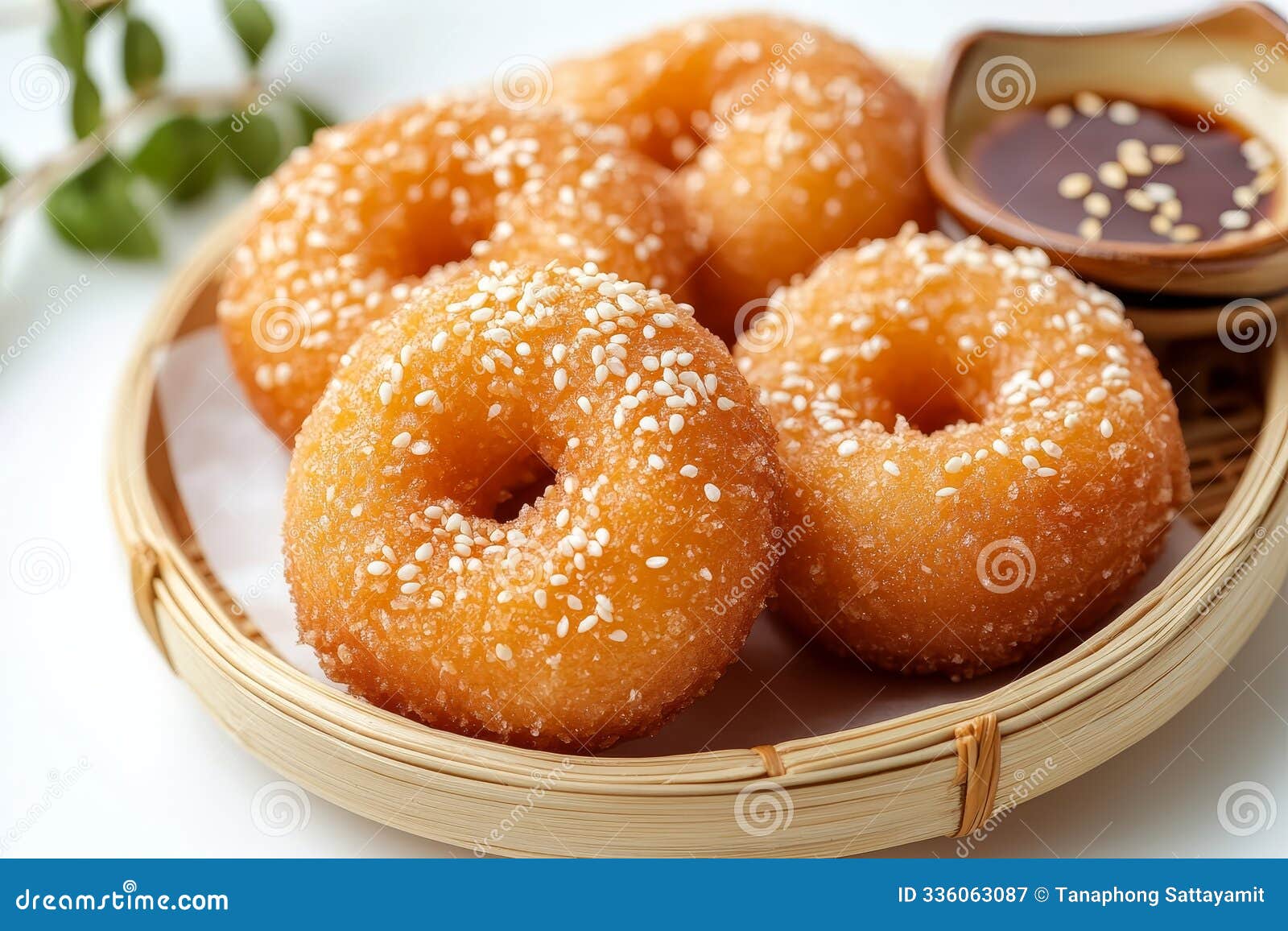 a closeup of four golden brown chapssal donuts traditionally made with glutinous rice flour dusted with sesame seeds and