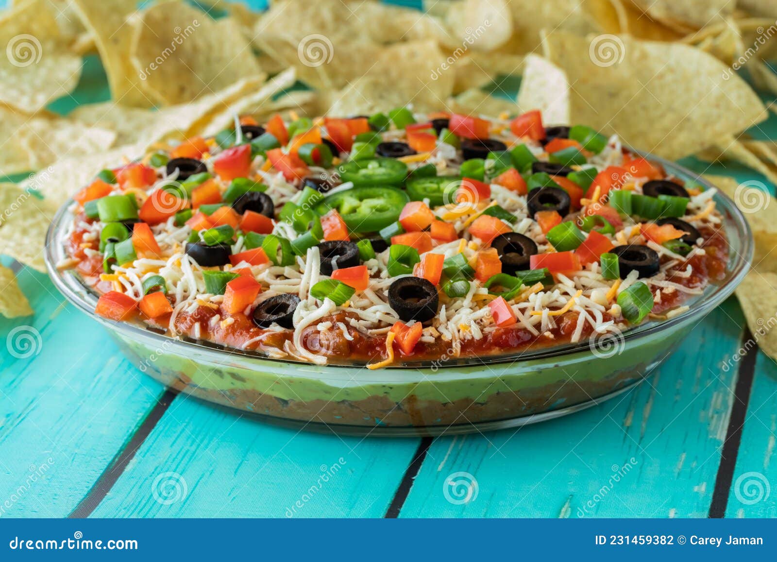 Close Up of a Freshly Made Mexican Layered Dip, with Chips in Behind