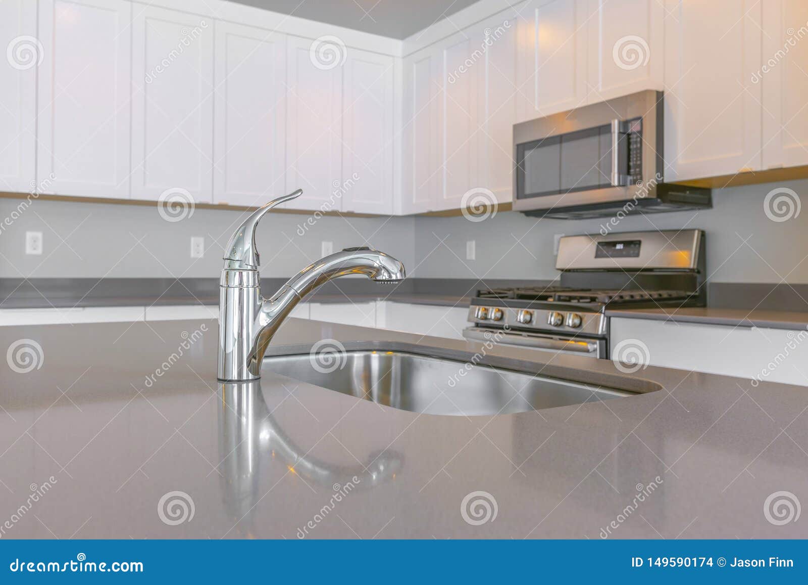 Close Up of a Glossy Countertop with Faucet and Sink Inside a Modern ...