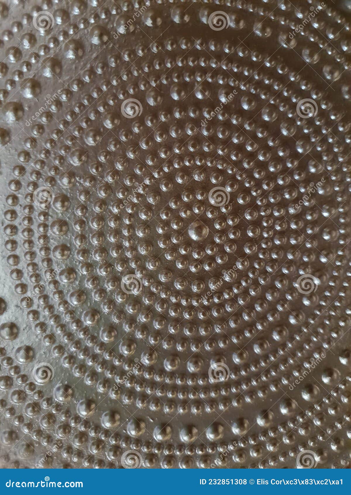 close-up of a golden metal surface, mandala  with balls of various sizes forming various circles.