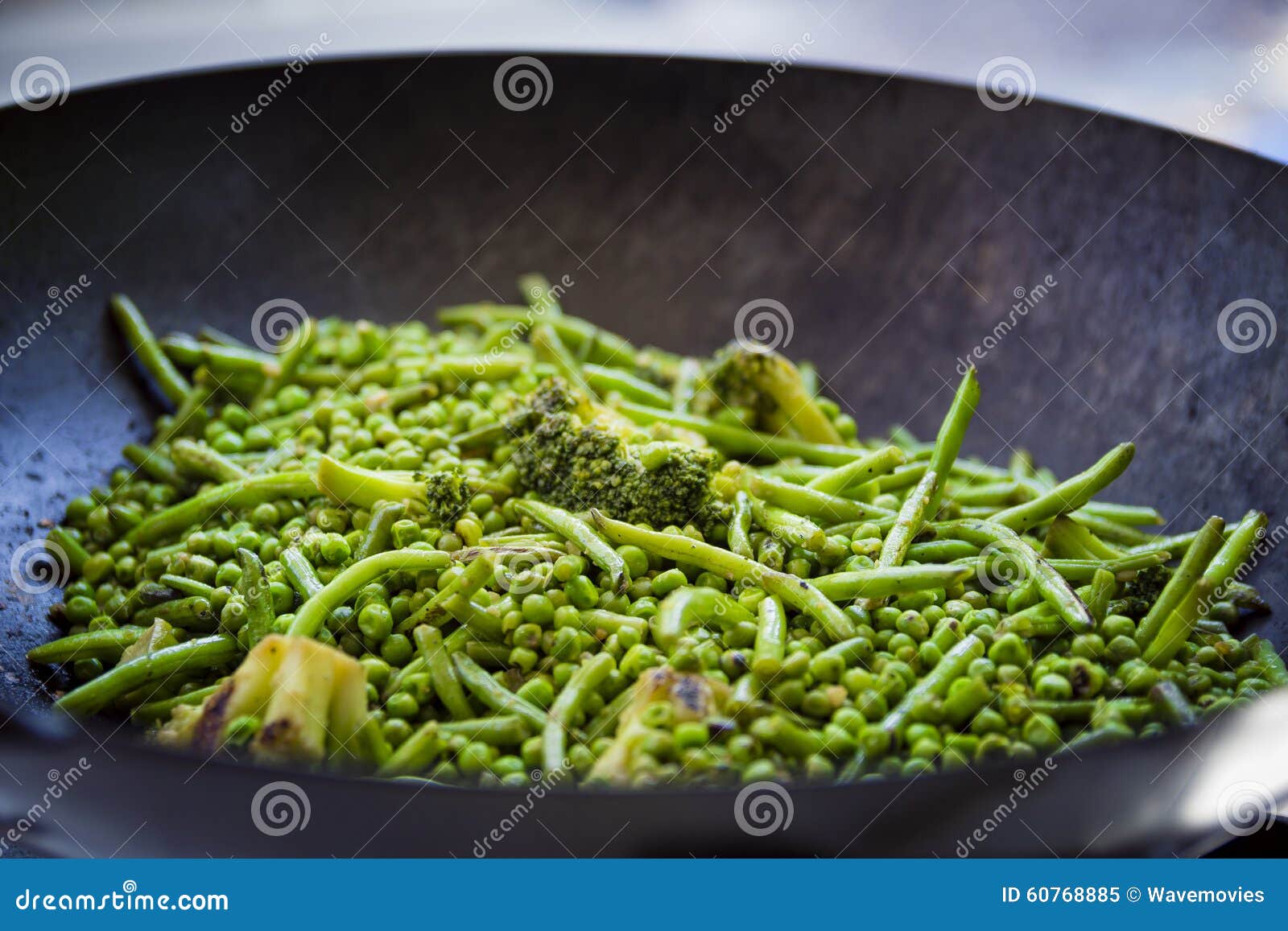 Close Up on Green Beans, Broccoli and Peas are Cooked in a Big Iron Pan