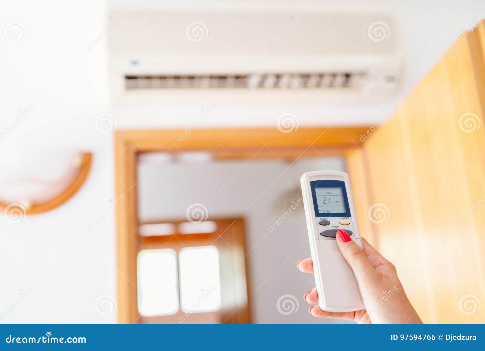 Close Up on Hand Adjusting Temperature of Home Air Conditioner Stock