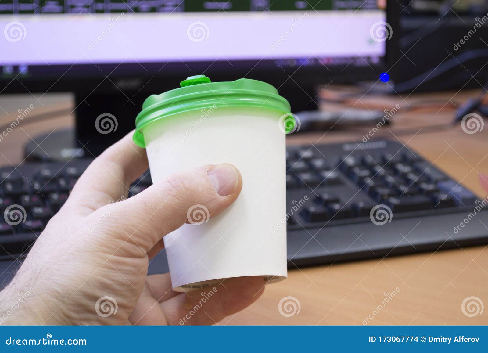 close-up of hand with cup of coffee on working place