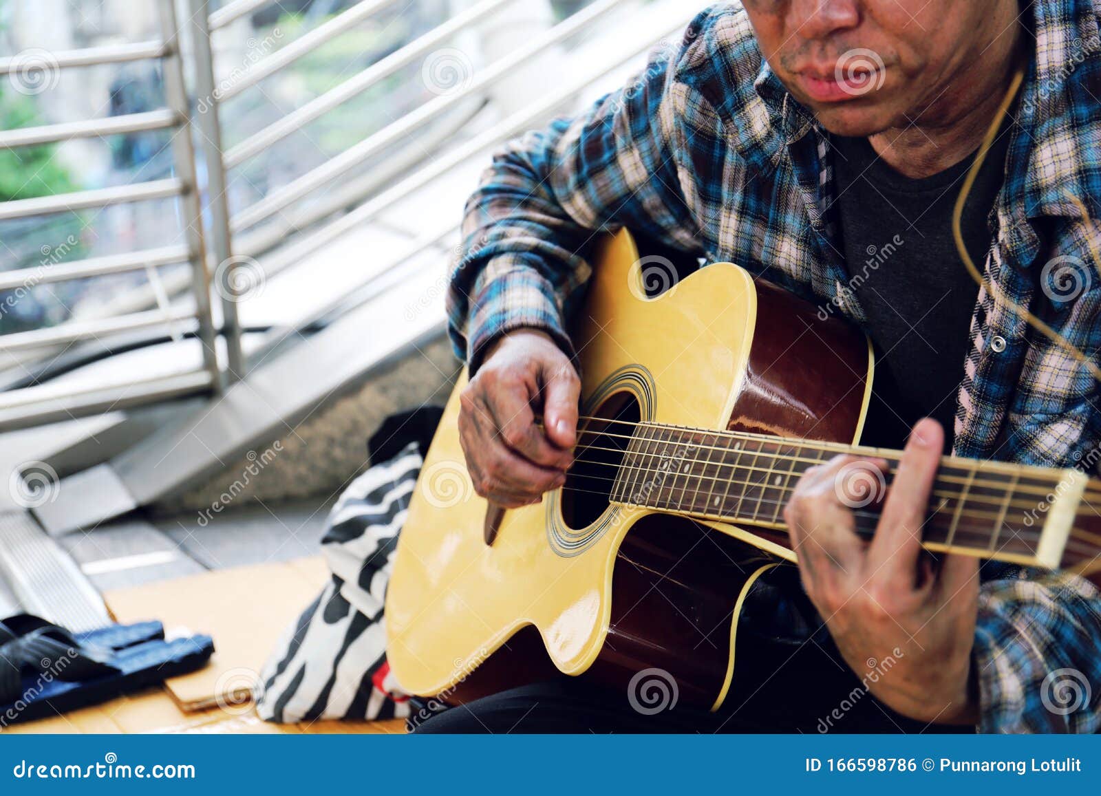 Close-up Hand of Homeless Asia Man Playing Acoustic Guitar on Walking