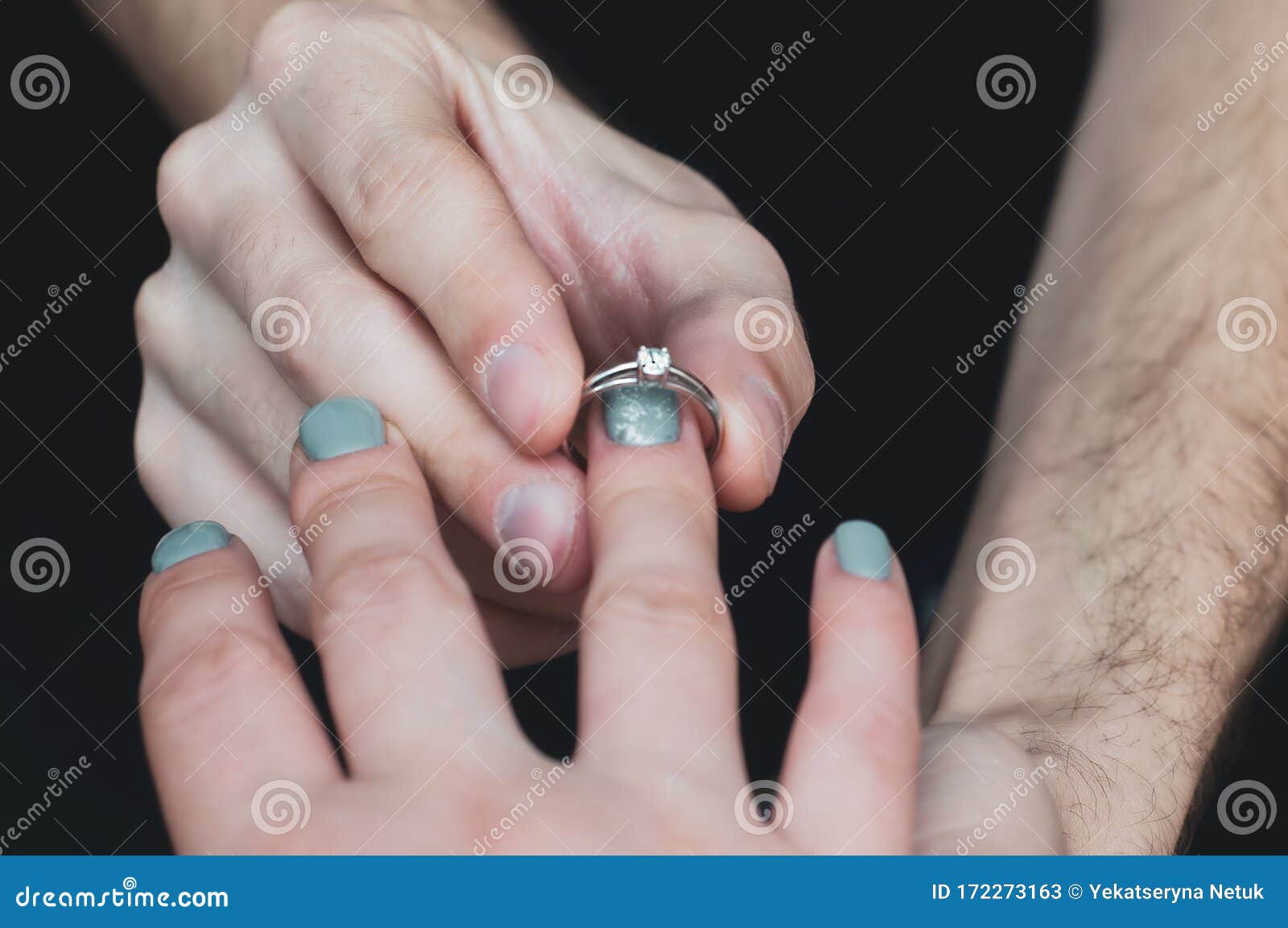 Close Up on Hand of a Man Put on an Engagement Ring on the Finger of