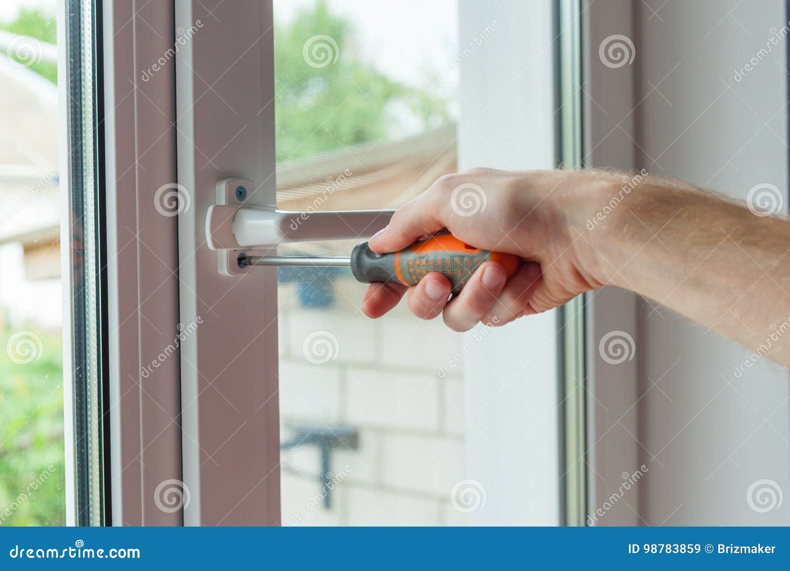 close-up, hand with a screwdriver tightens the fixing of the window limite