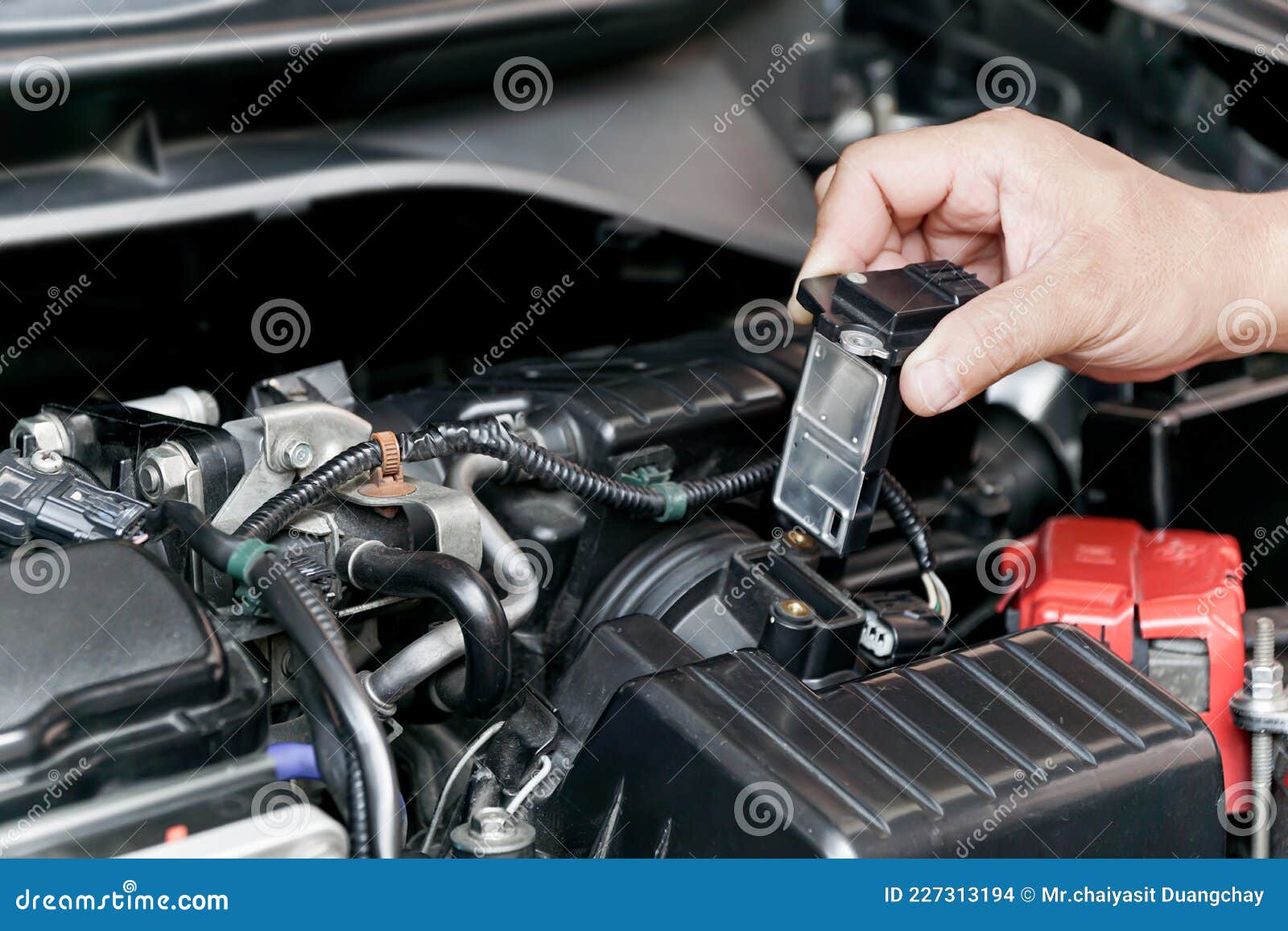 hand a technician remove airflow sensor in the engine room car for check and cleaning in service concept