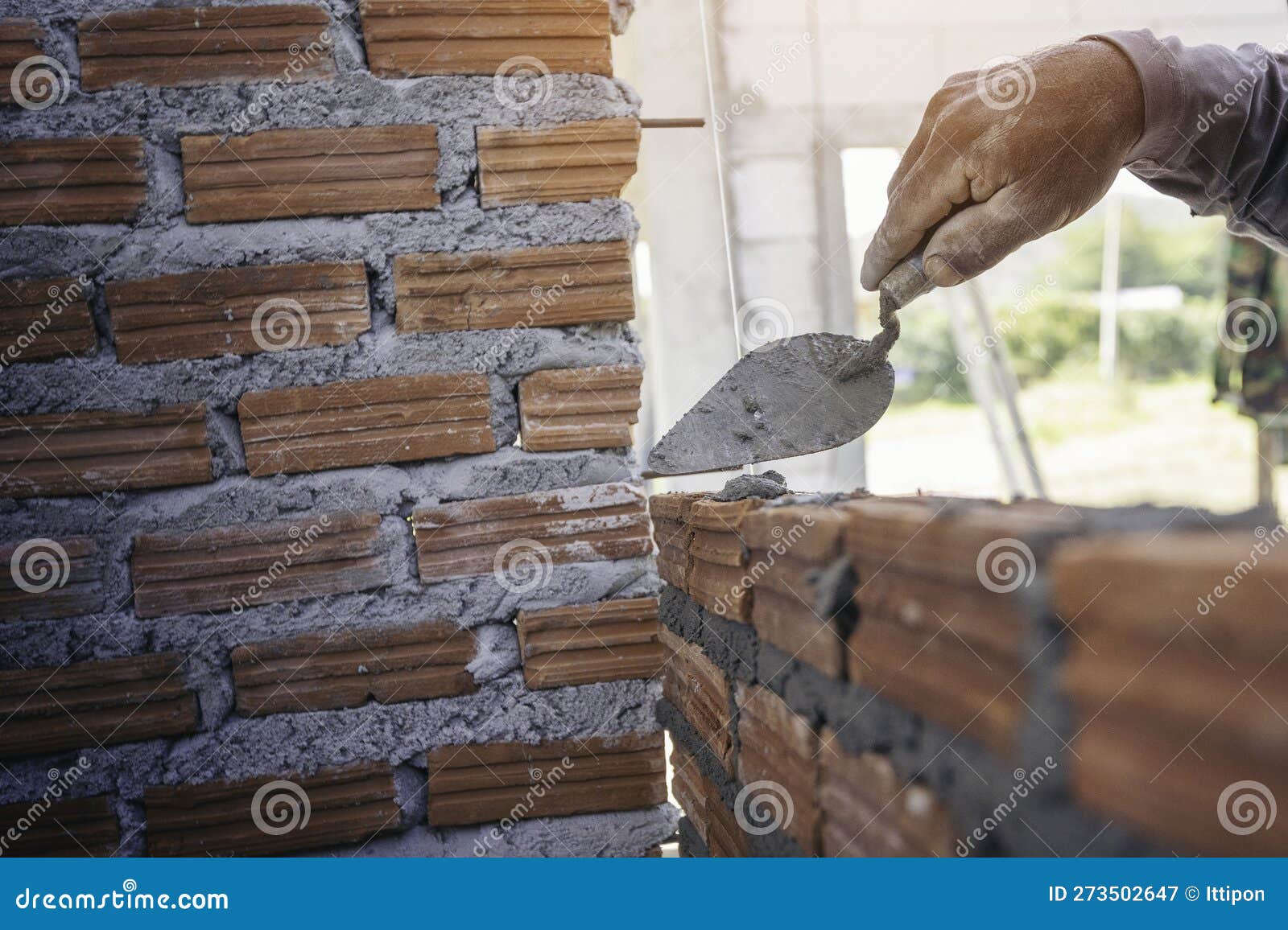 Hand of Worker Installing Bricks on Construction Site Stock Image