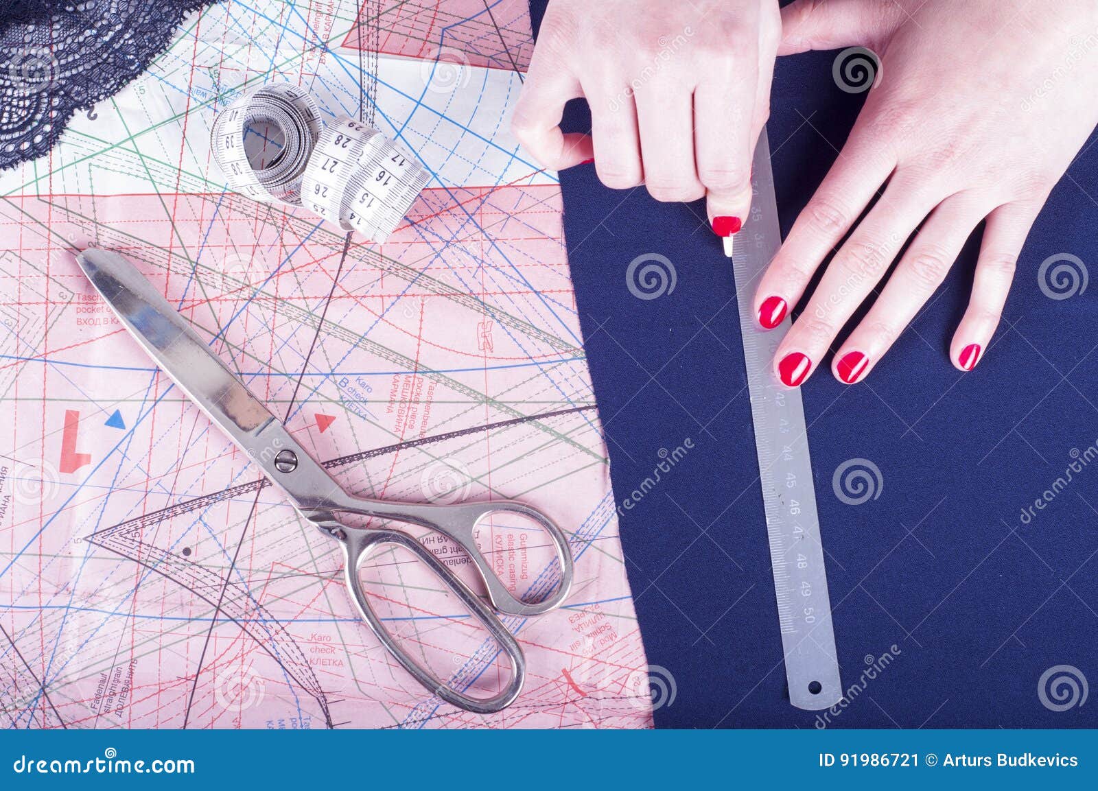 Female hands of designer at work with fabric close-up. Tailor