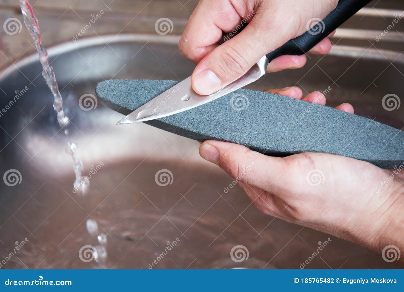 Premium Photo  Close-up strong male hands sharpen a kitchen metal knife  with a grindstone. home household knife sharpening. top view. group of  knives