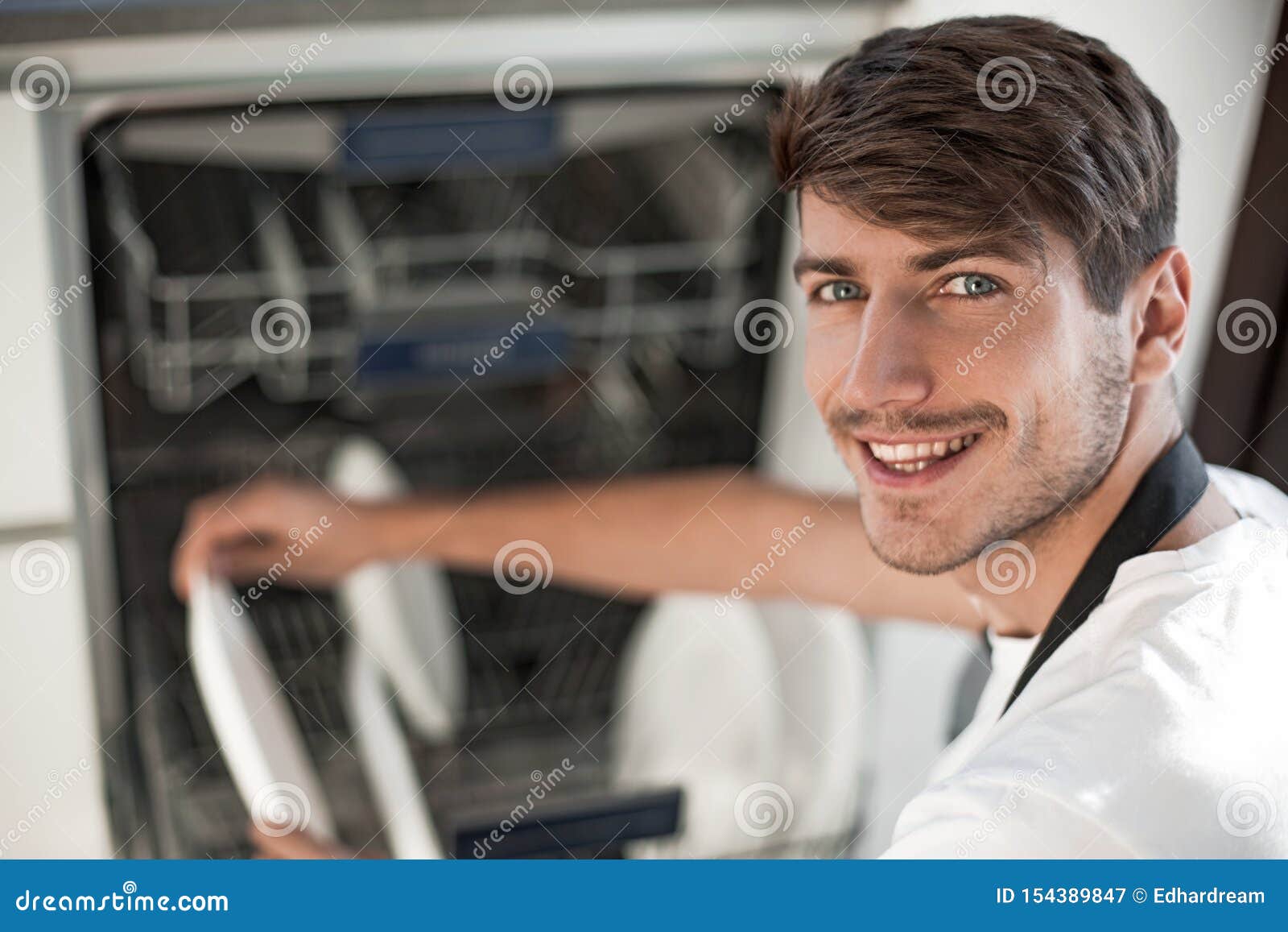 Close Up. Handsome Young Man Using Dishwasher Stock Image