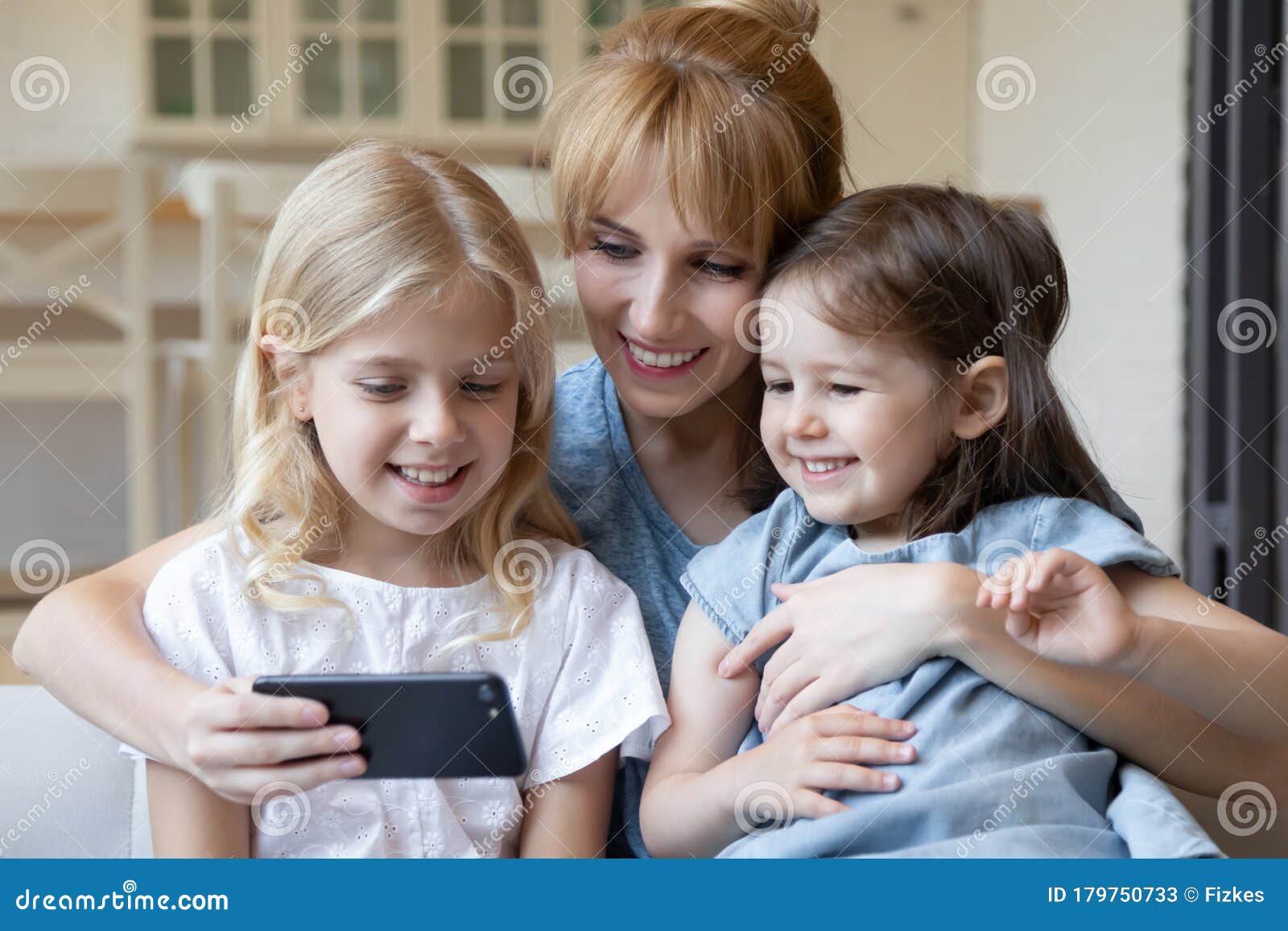 Close Up Happy Mother with Little Children Using Smartphone Together ...