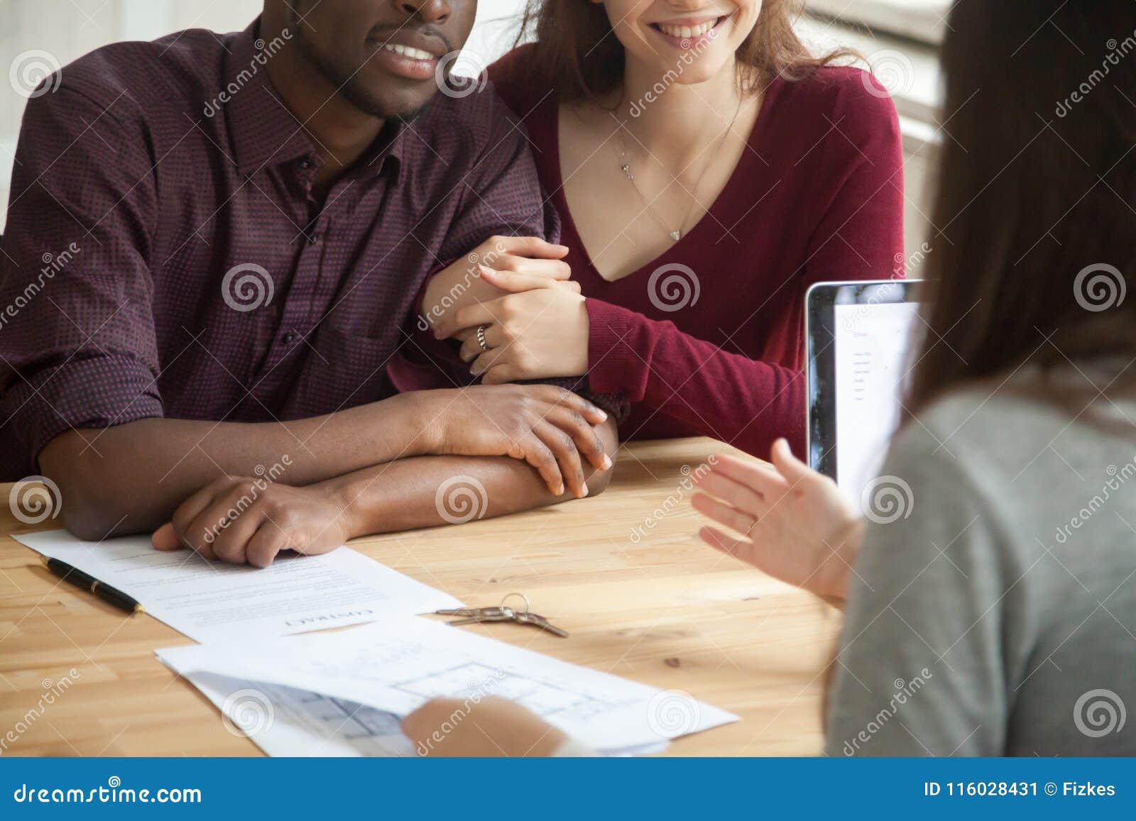 close up of happy multiracial couple buying home