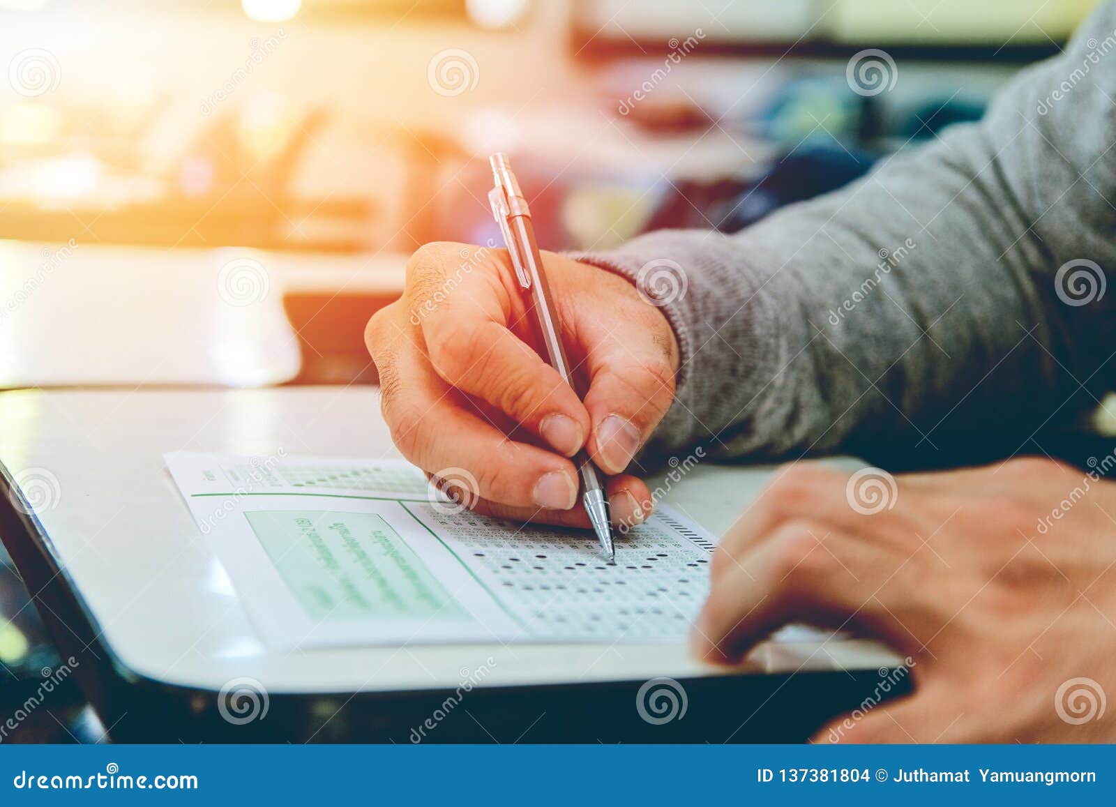 close up , high school male student holding pencil exams writing in classroom for education test ,copy space for your text.
