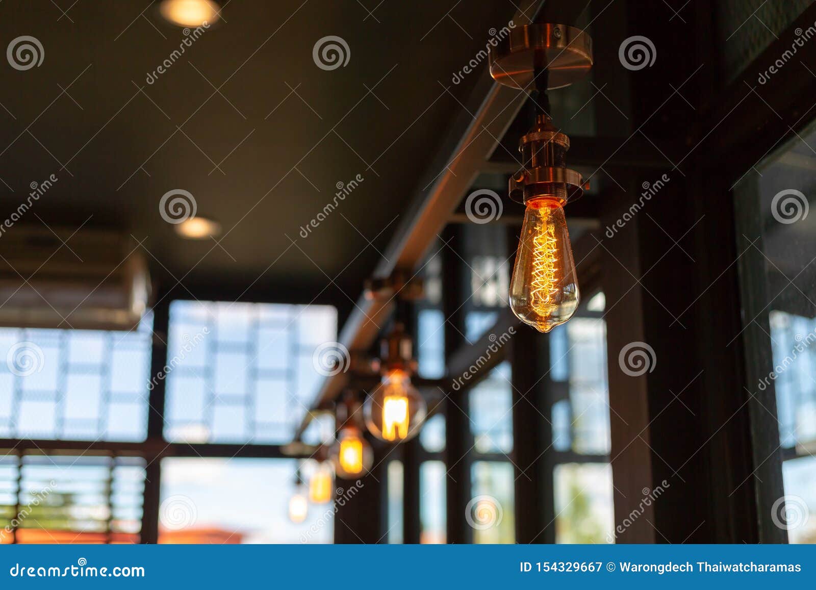 Close Up of Illuminated Light Bulb in Coffee Shop with Copy Space Stock