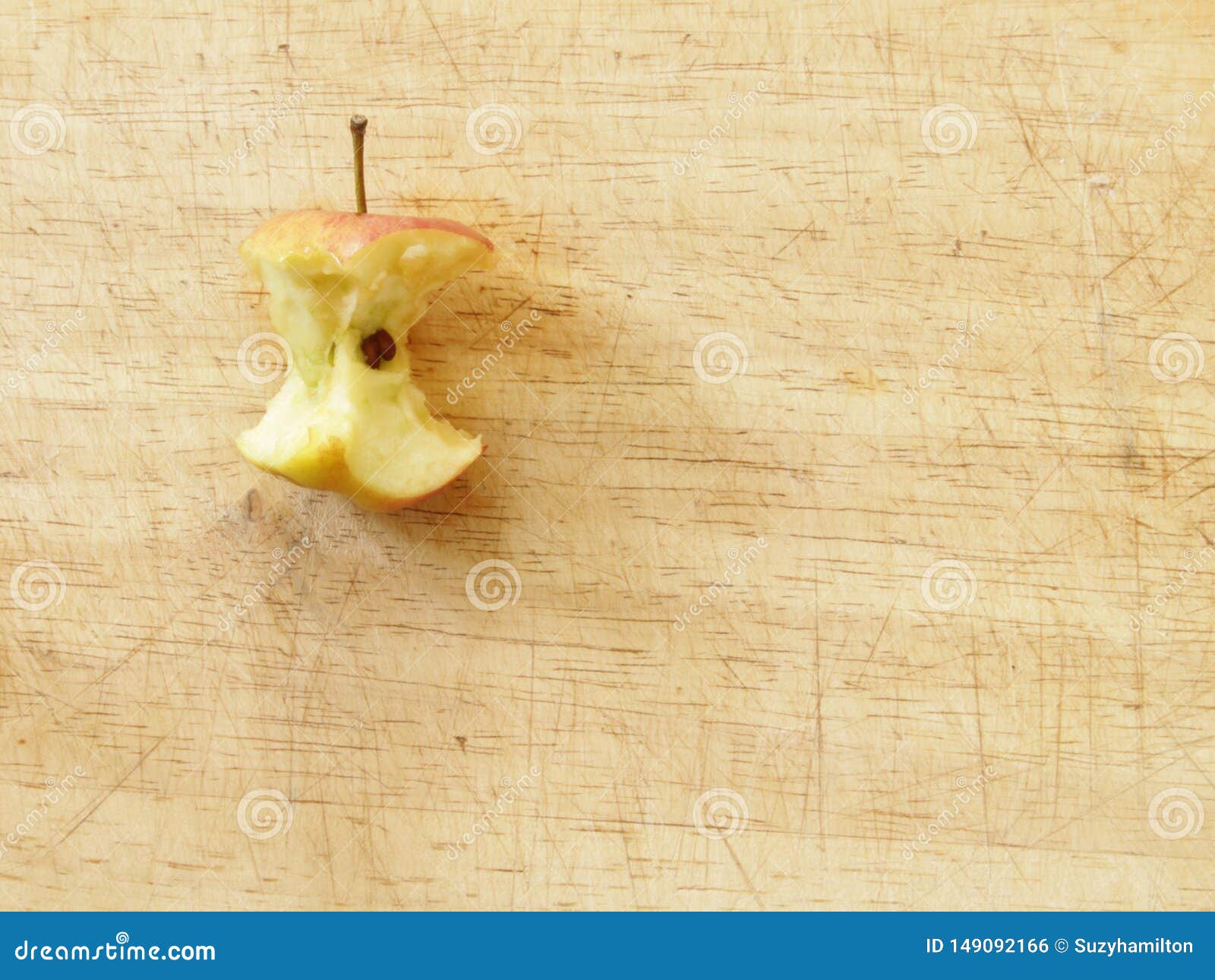 close up red apple core on a wooden board from above