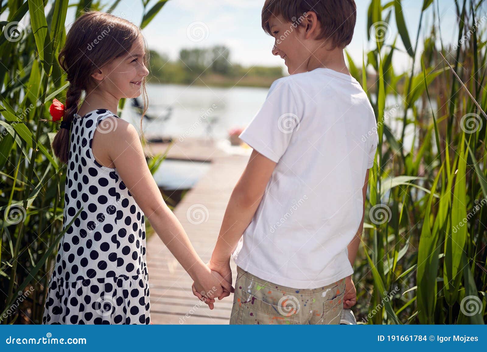 Close Up Image Of Caucasian Boy And Girl Holding Hands Walking Toward The Water Stock Photo Image Of Children Amusing