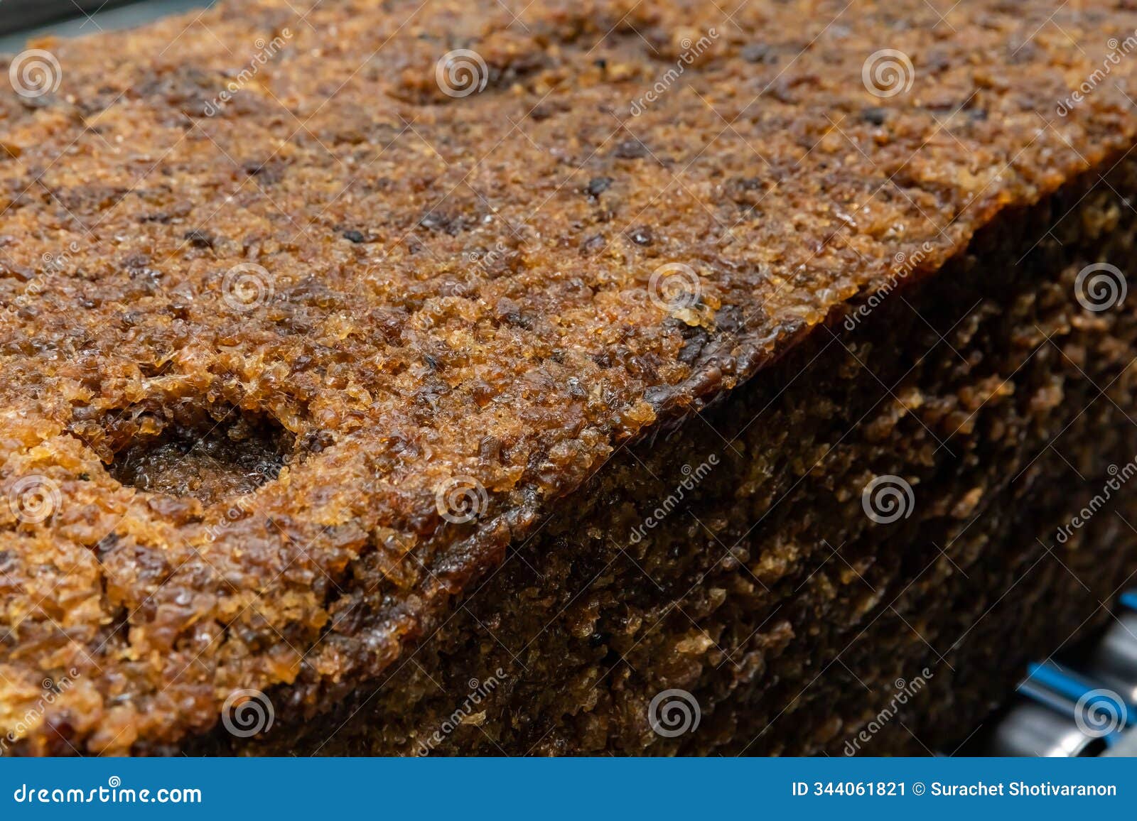 the close up image of the jagged brown natural raw rubber bales surface, lumpy solid block standard thai rubber, in a factory
