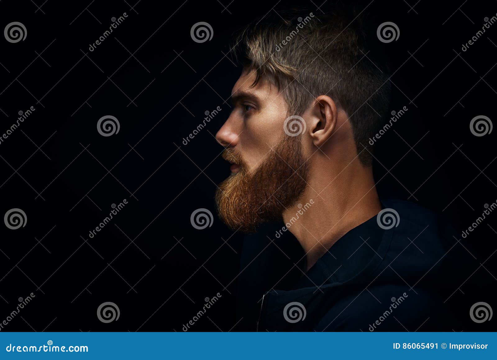 close-up image of serious brutal bearded man on dark background