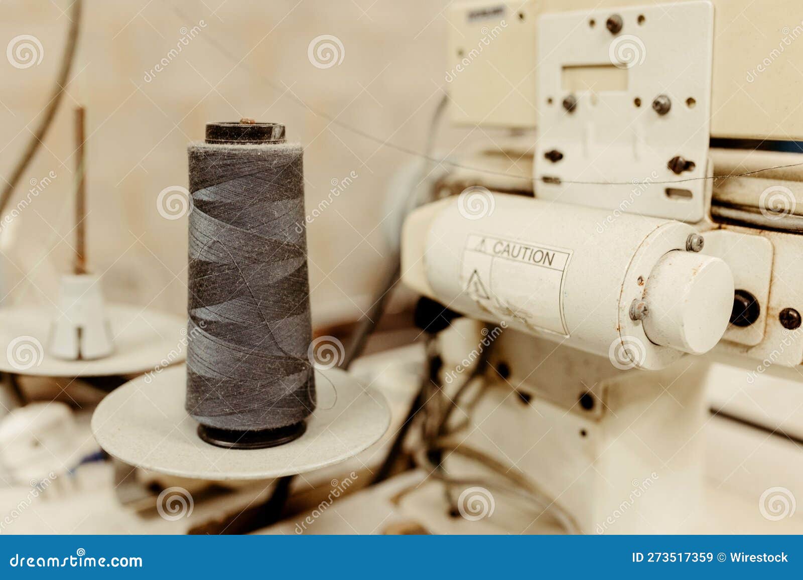 Closeup Image of a Sewing Machine with a Spool of Thread Being Worked