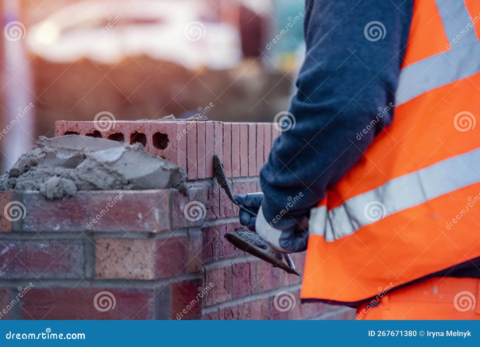 Close Up of Industrial Bricklayer Laying Bricks on Cement Mix Stock