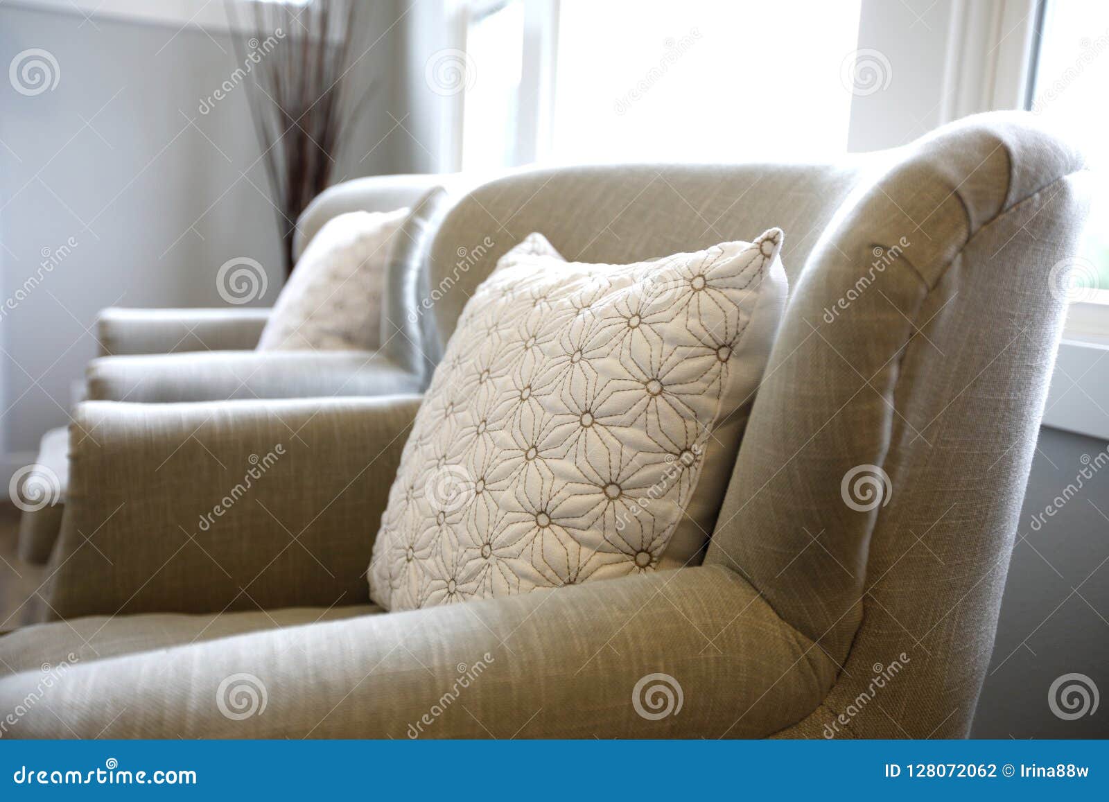 Closeup of an Ivory Armchair Topped with a Pillow Stock Photo Image