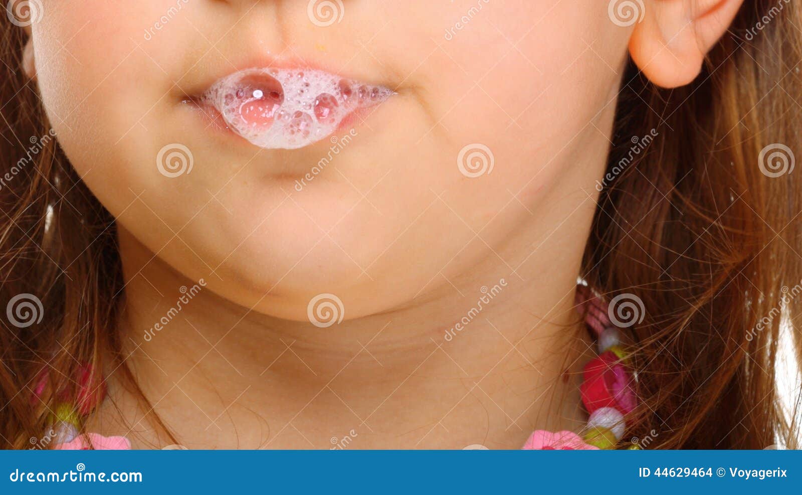 close up little girl doing fun saliva bubbles