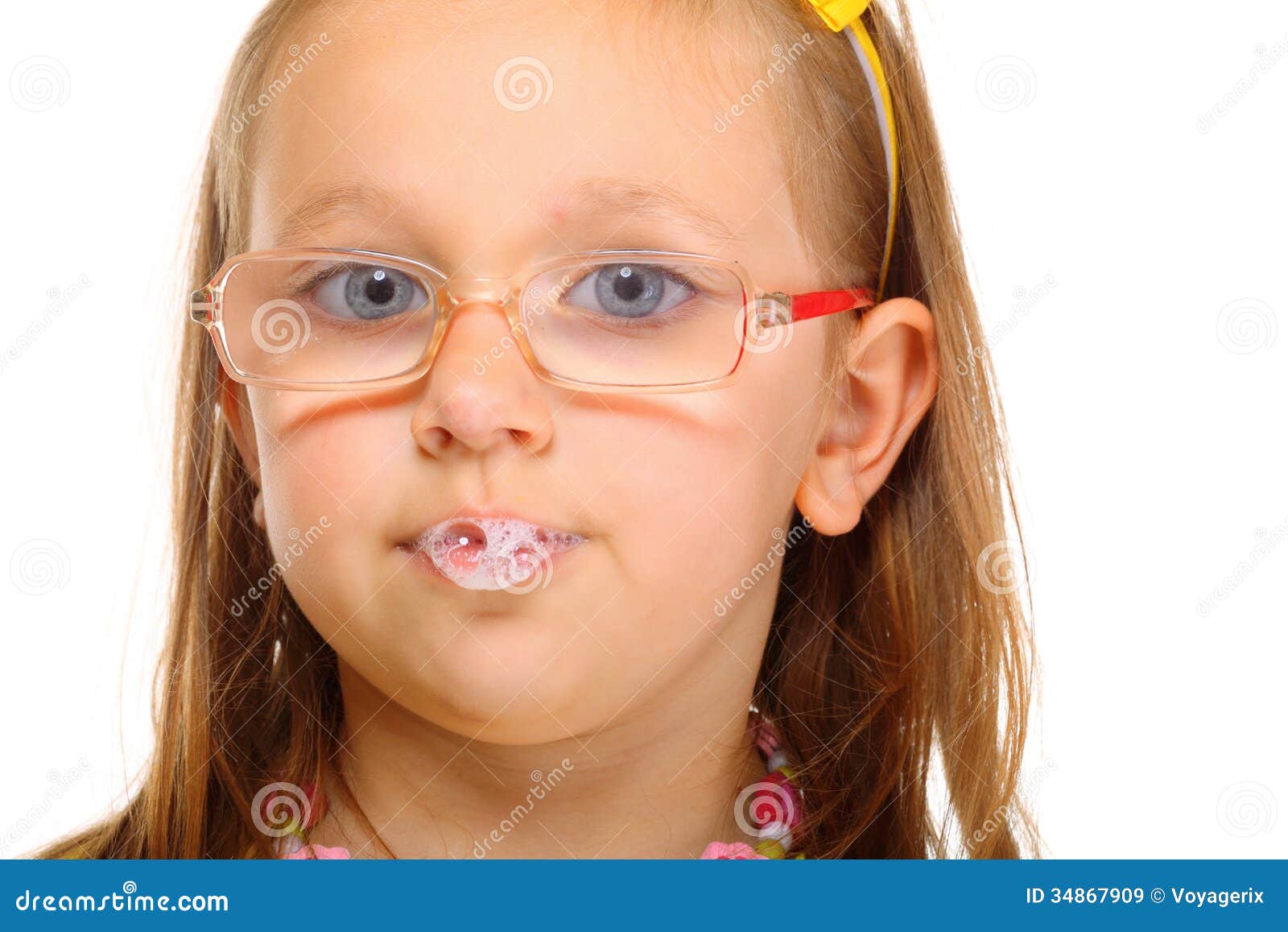 close up little girl in glasses doing fun saliva bubbles