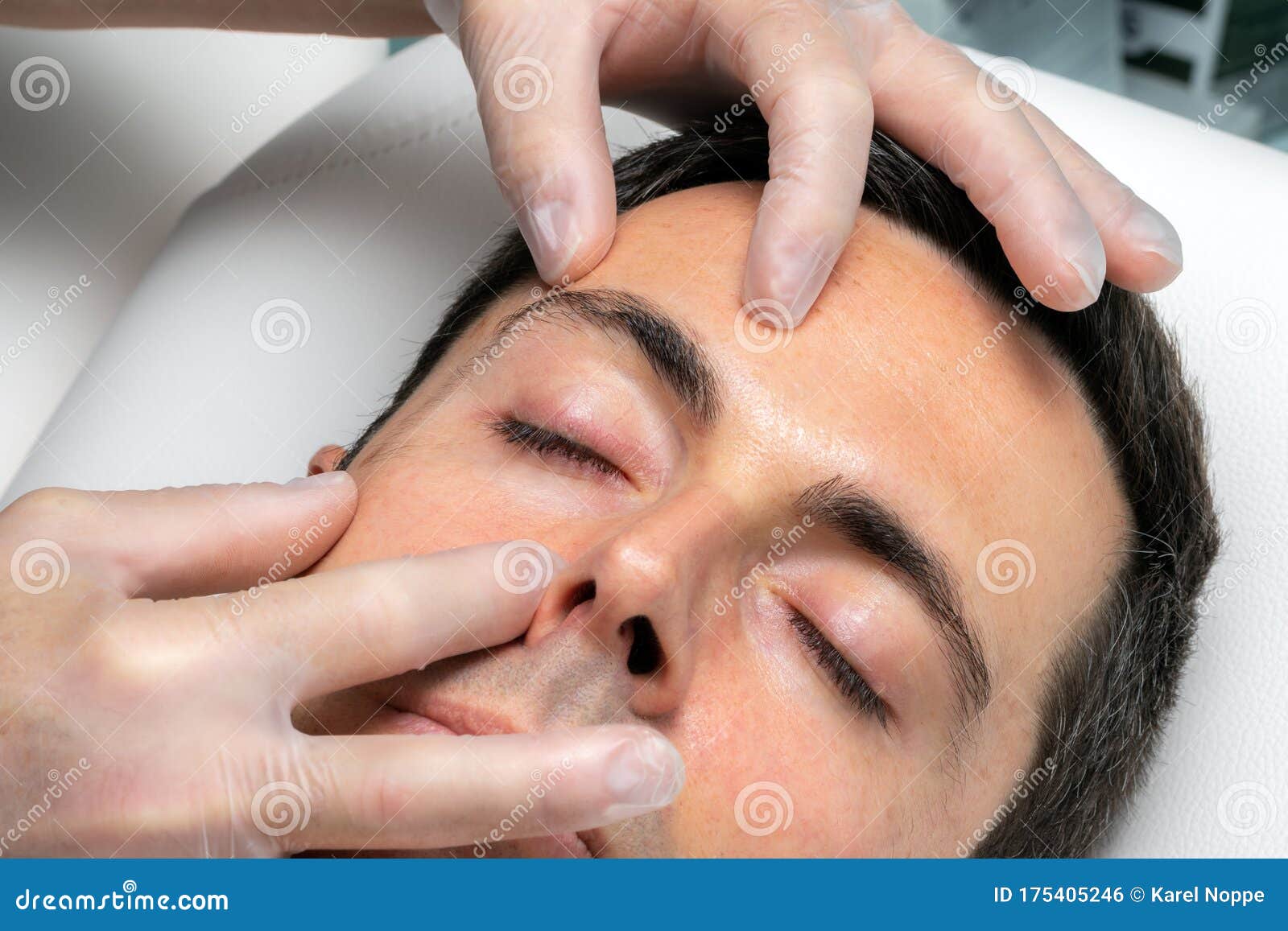 hands with medical exam gloves inspecting eyelid of middle aged man