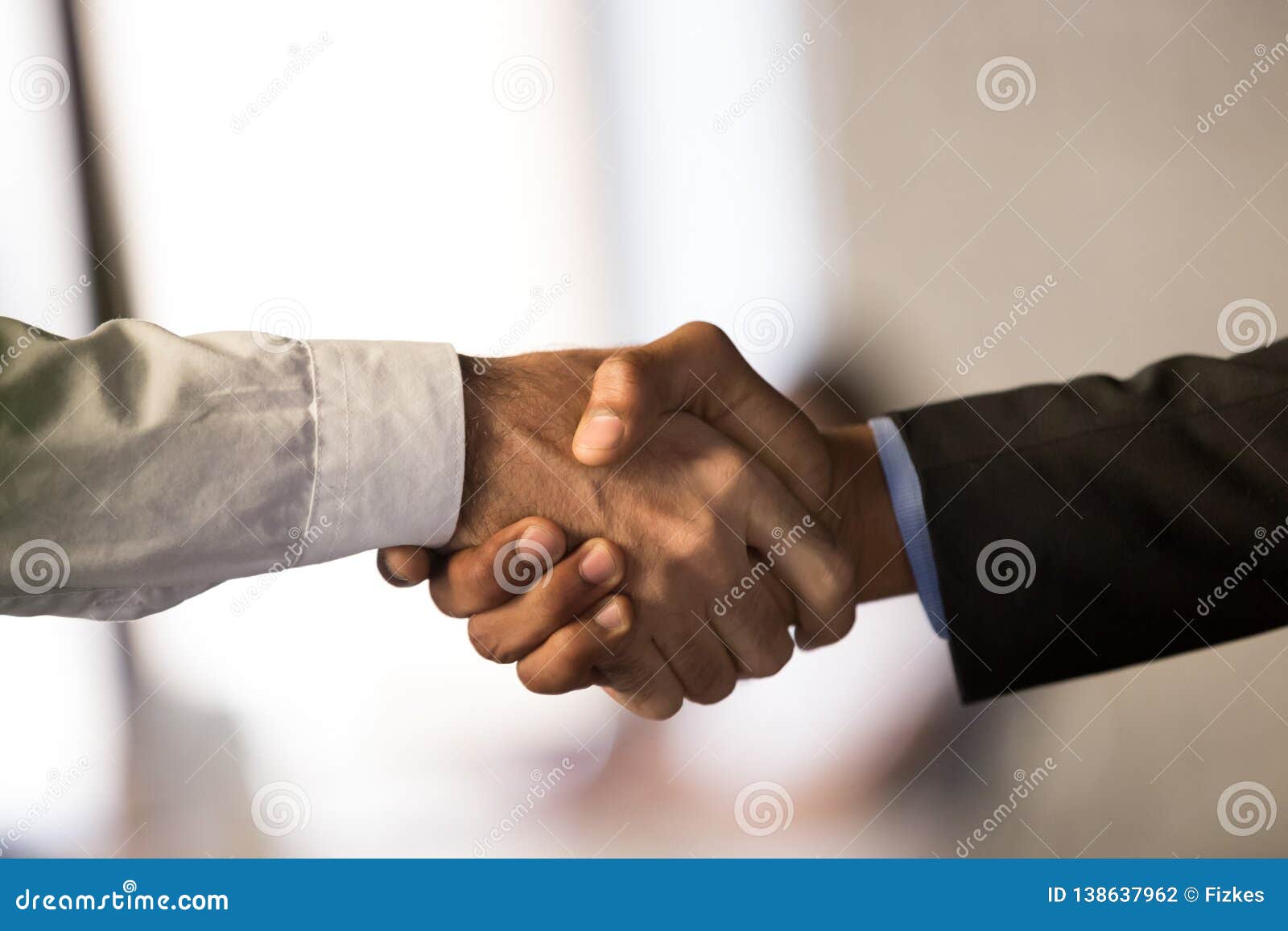 close up of male employees handshake closing deal