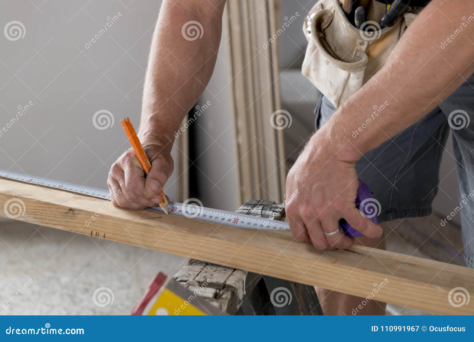 close up male constructor carpenter or builder hands detail working and measuring wood in industrial construction job concept