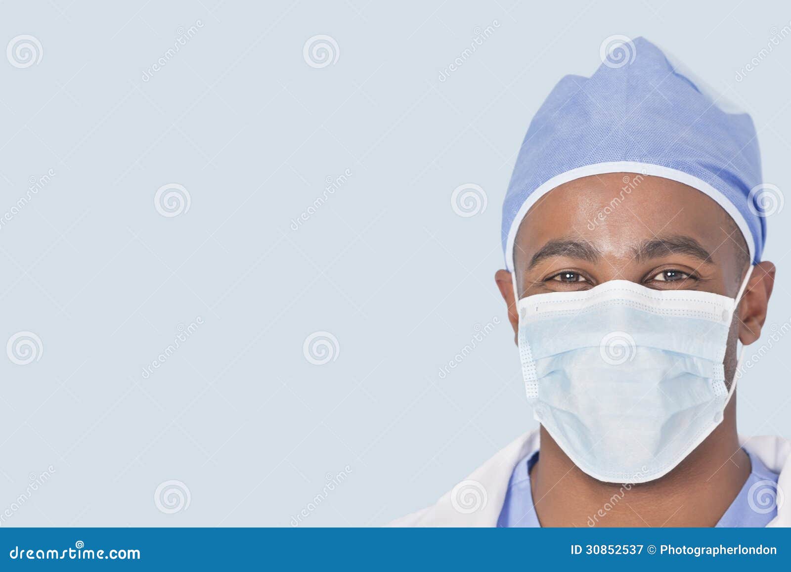 close-up of a male doctor wearing facemask over light blue background