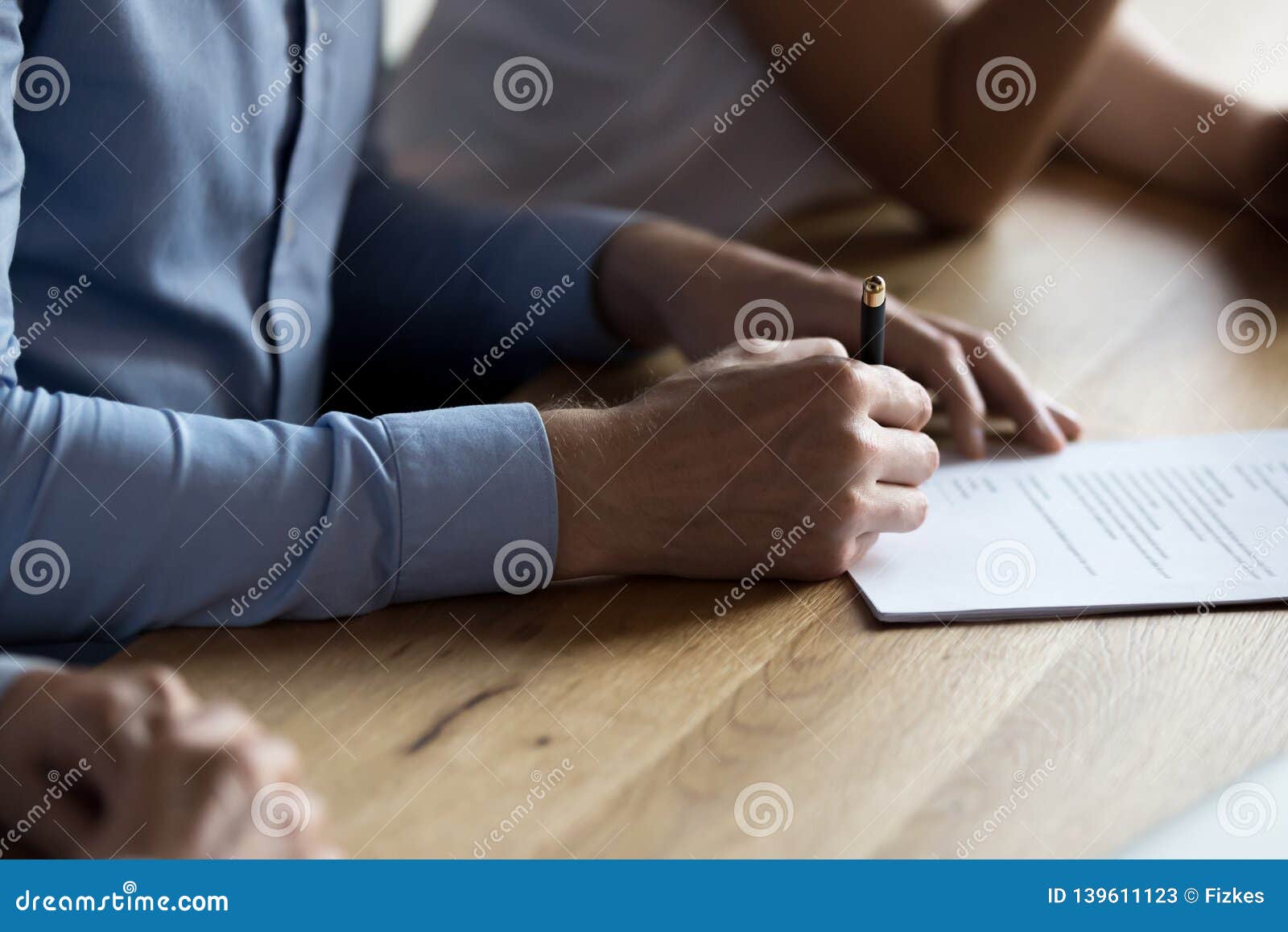 close up male hand holding pen and signing legal document