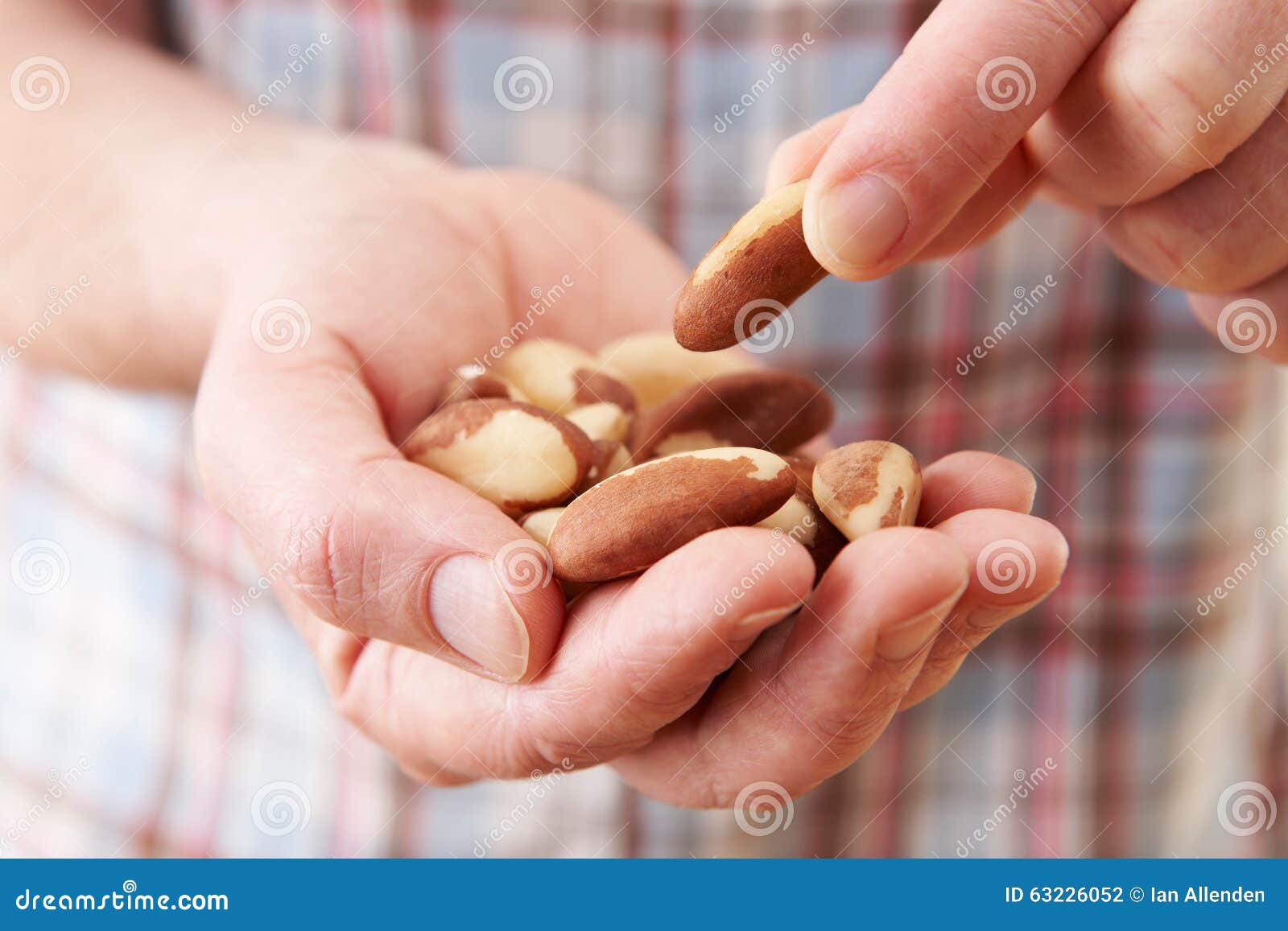 close up of man eating healthy snack of brazil nuts