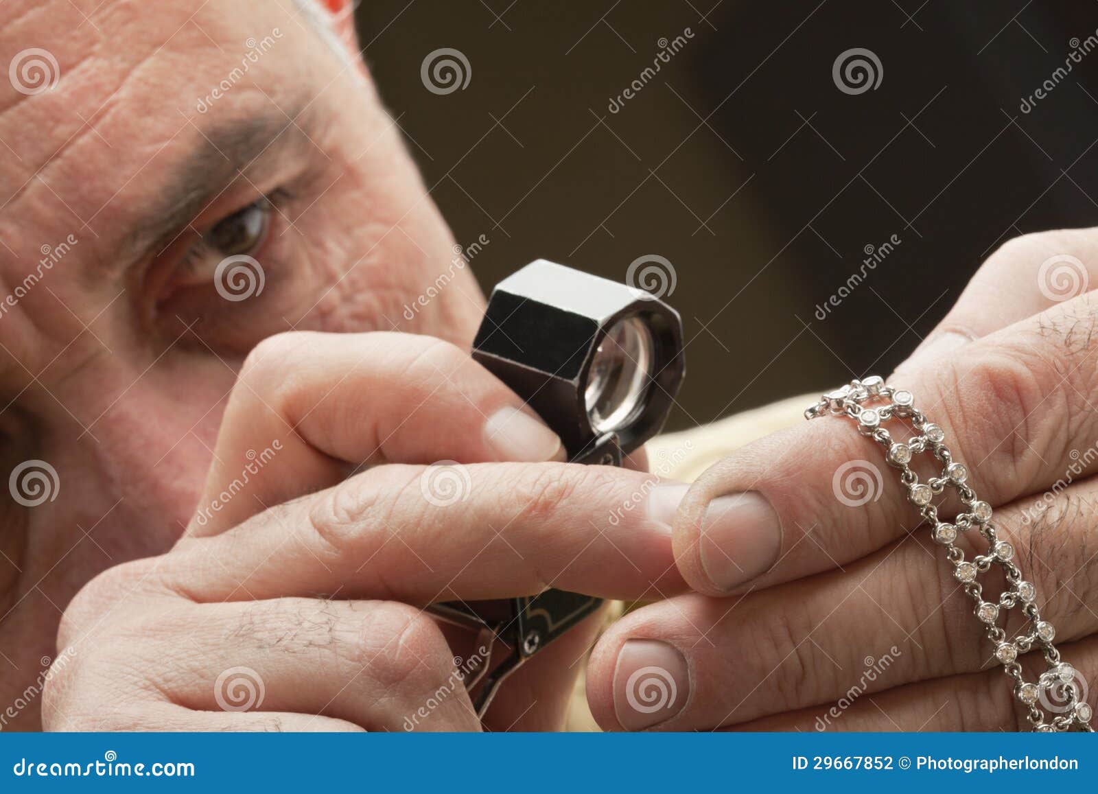 Close Up of Man Looking at Jewelry through Magnifying Glass Stock