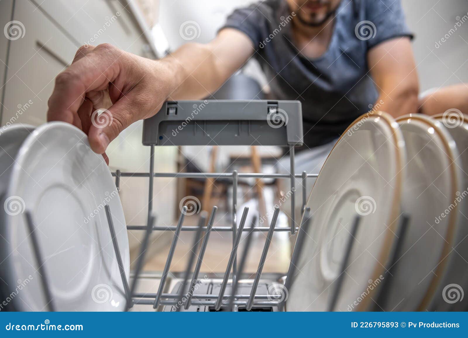 Closeup of a Man Pulls Out Clean Dishes from the Dishwasher Stock
