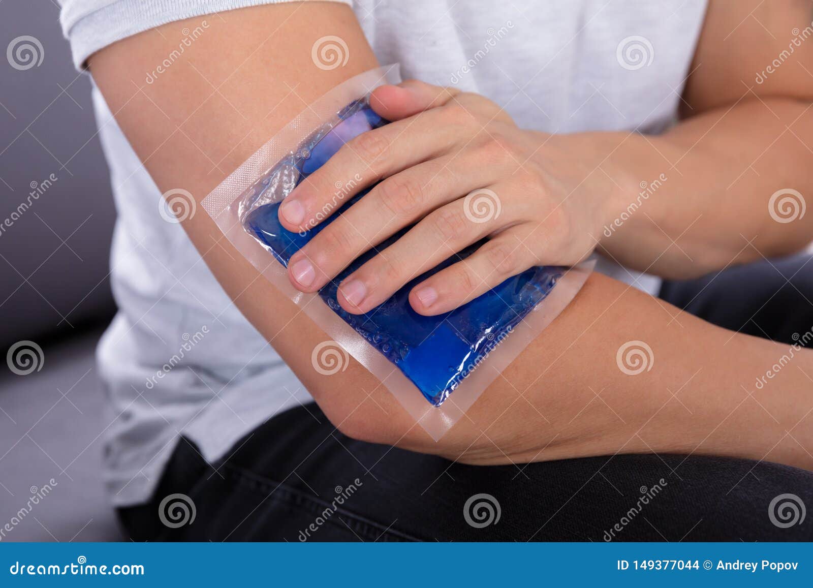 man applying ice gel pack on an injured elbow