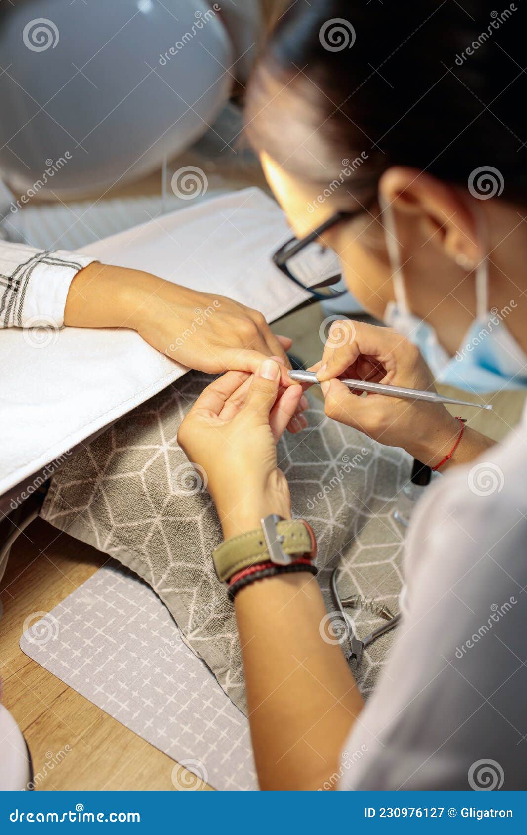 close-up of manicurist removing cuticles in nail salon