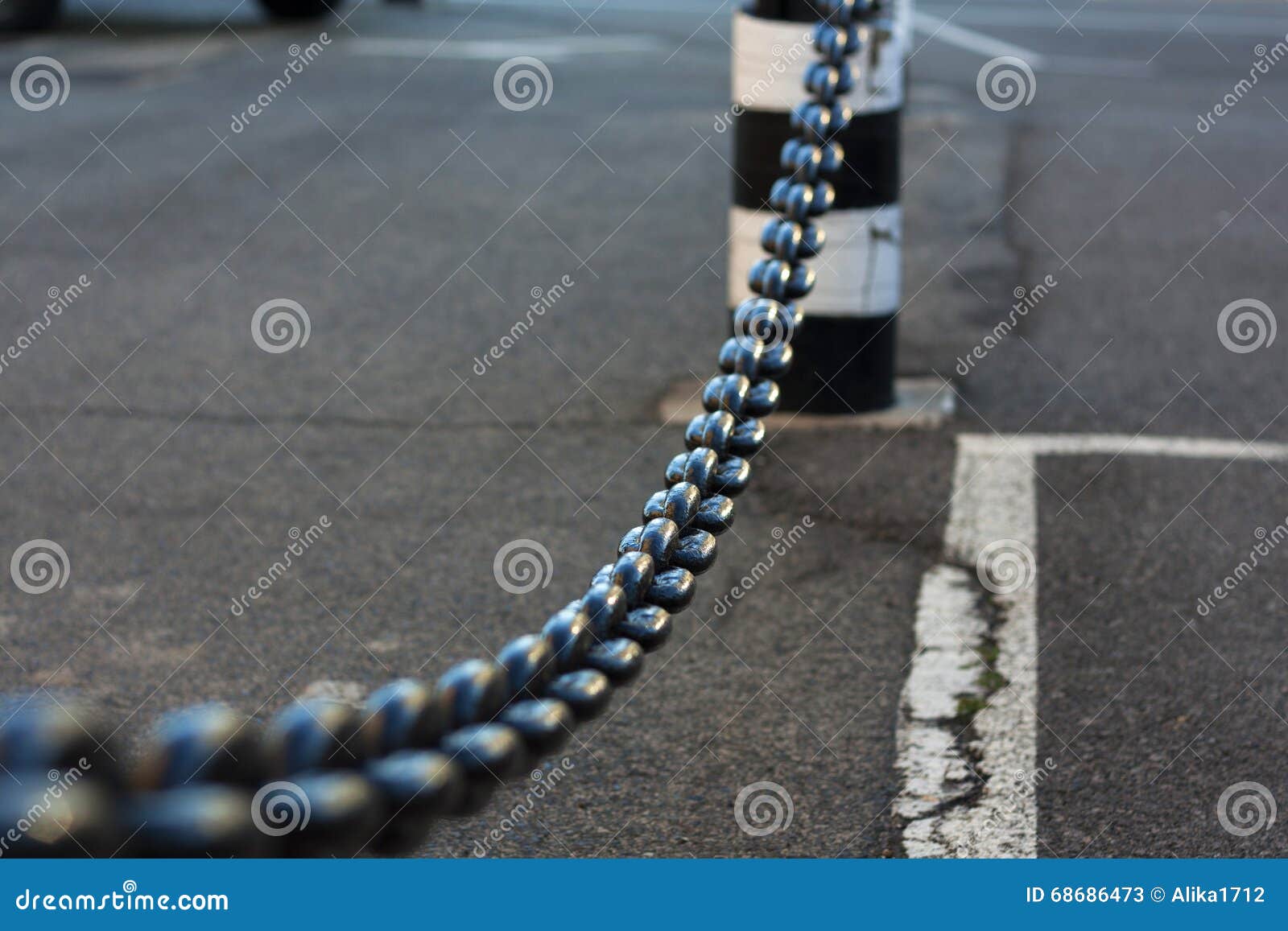 Close-up of metal chain vanishing in background. Hanging chain as safety barrier.