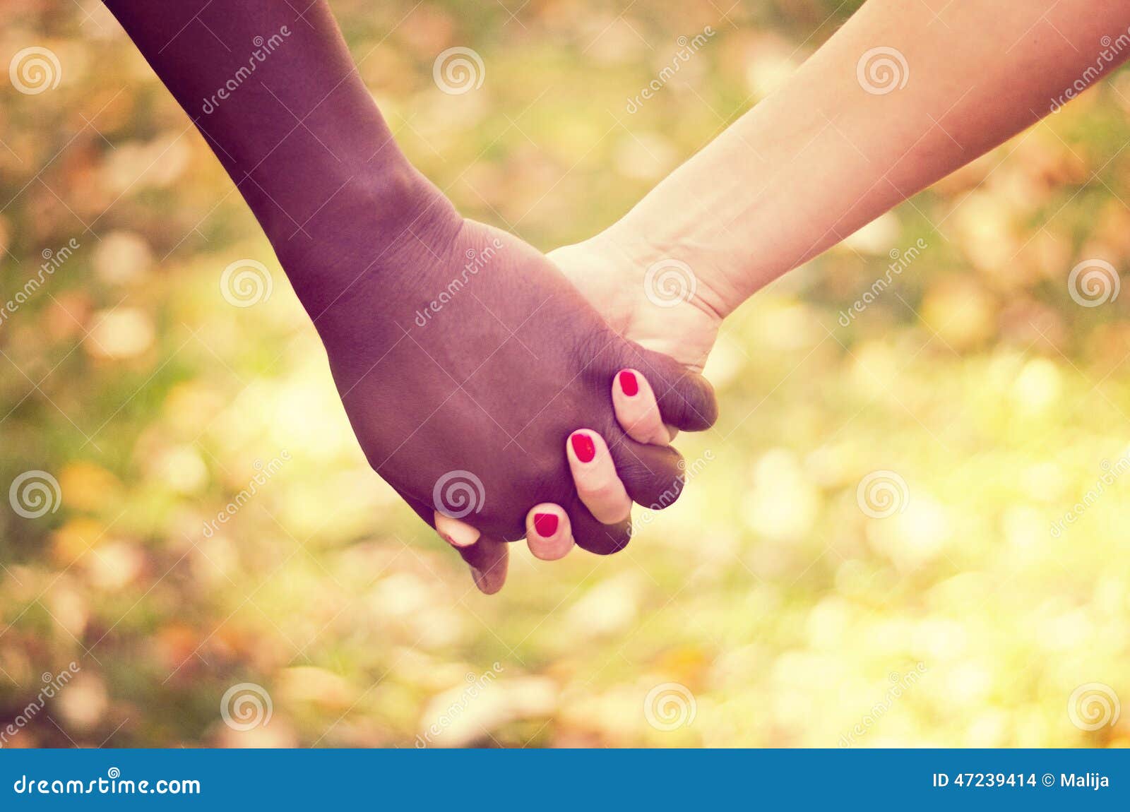 close up on a mixed race couple holding hands