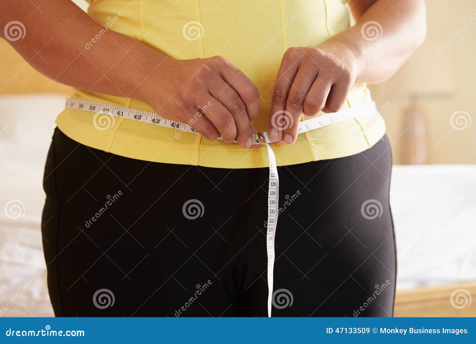 close up of overweight woman measuring waist