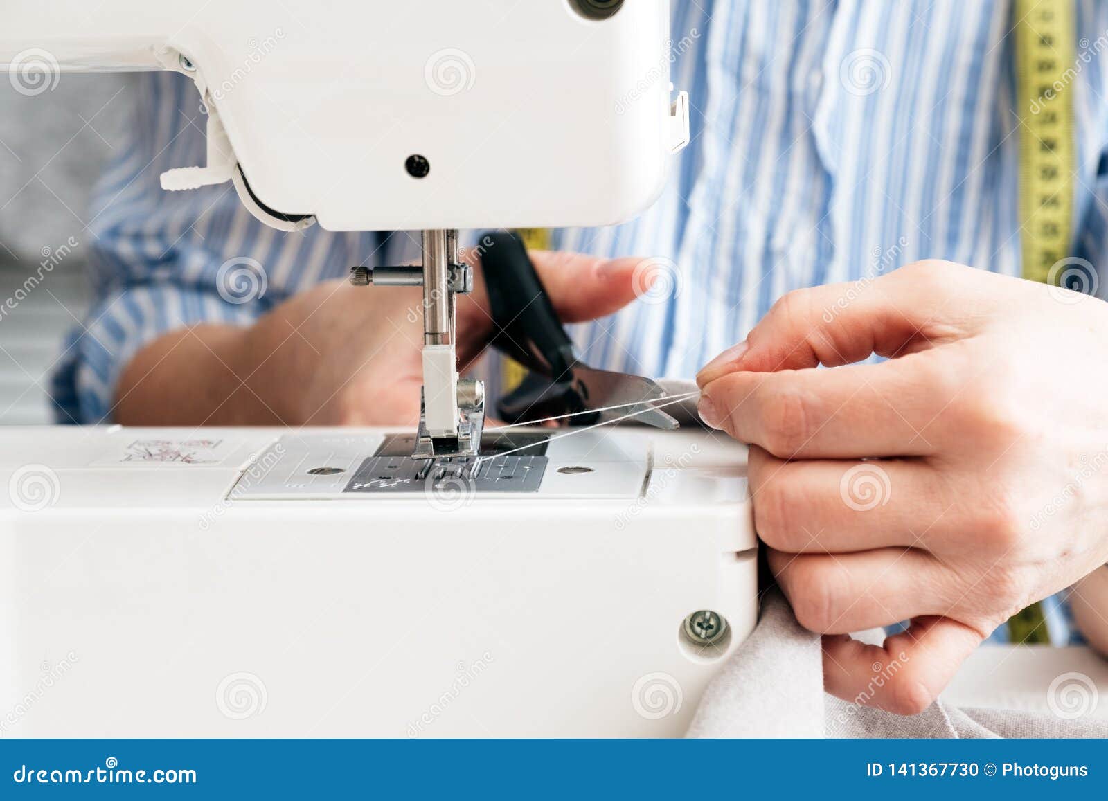 Closeup Partial View of Seamstress Working with Sewing Machine at
