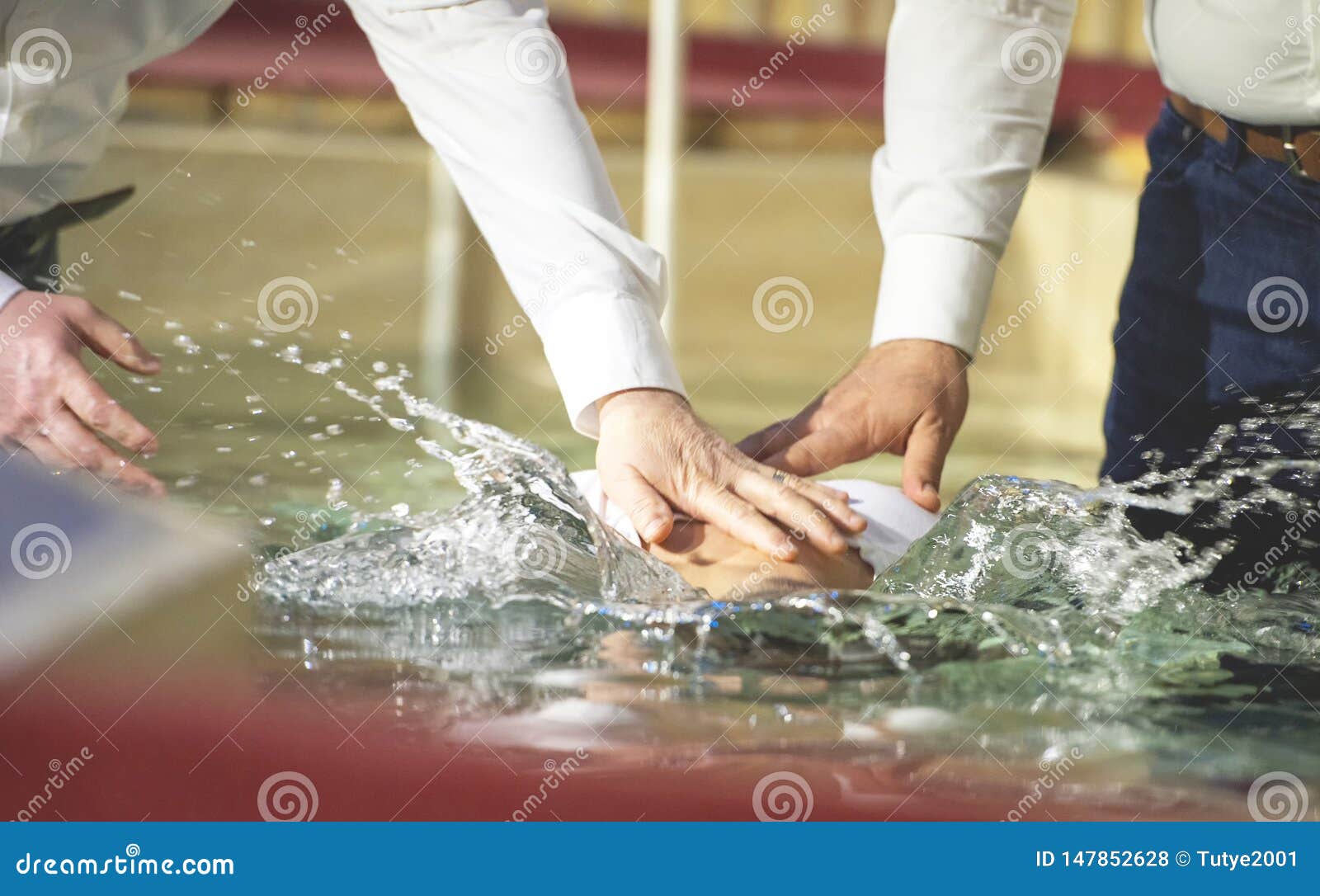 close up of pastors hands who baptize man