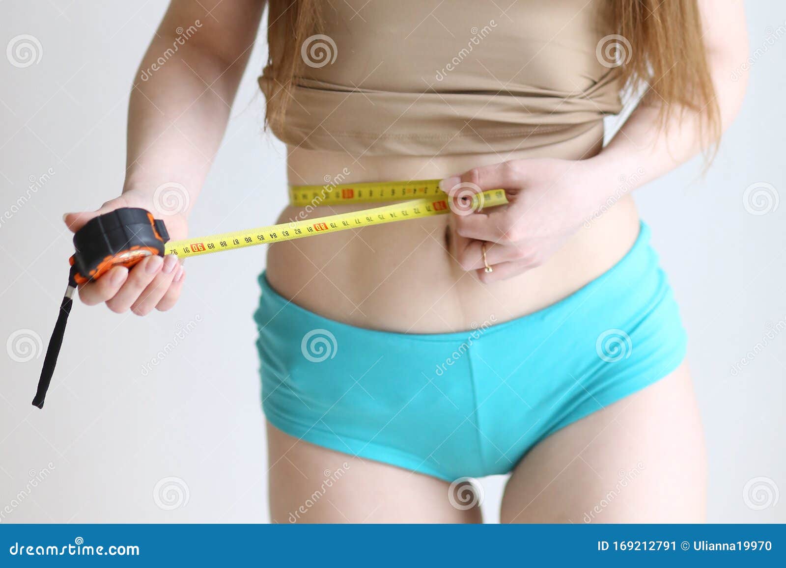 Close Up Photo of Model Girl Measure Her Waist with Measuring Tape