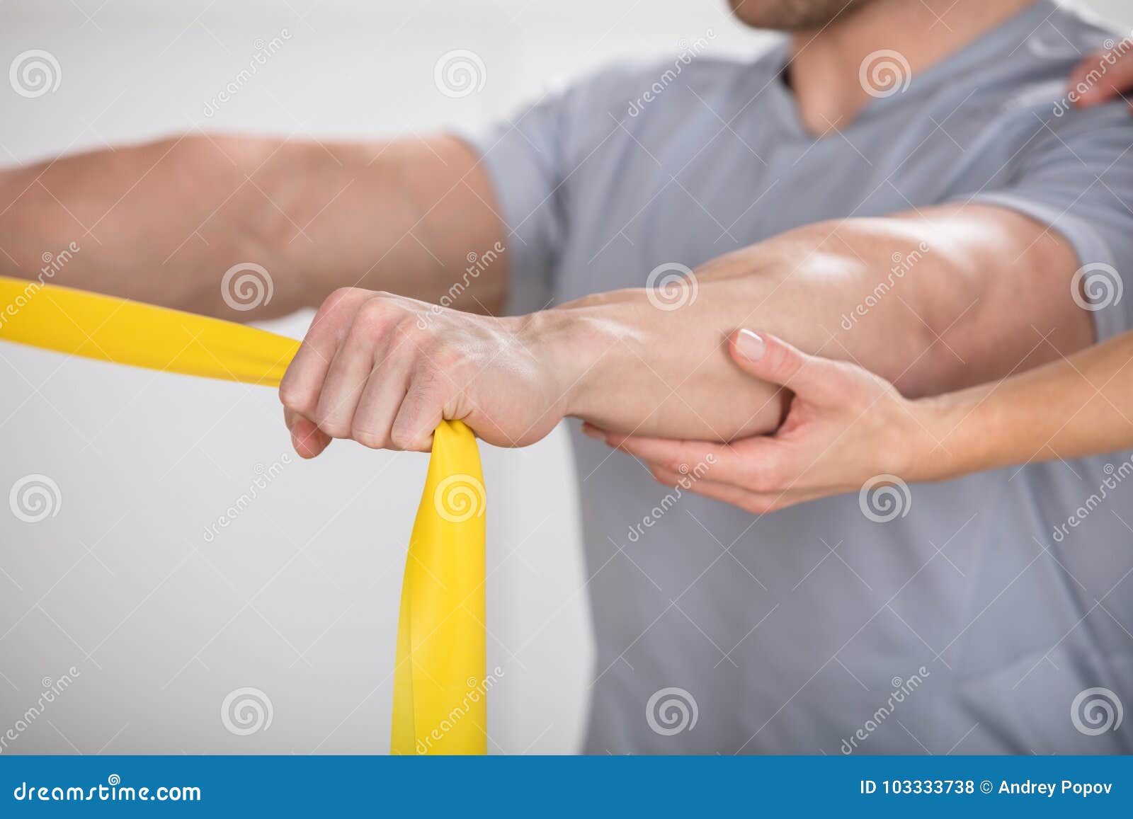 physiotherapist giving man a training with exercise band