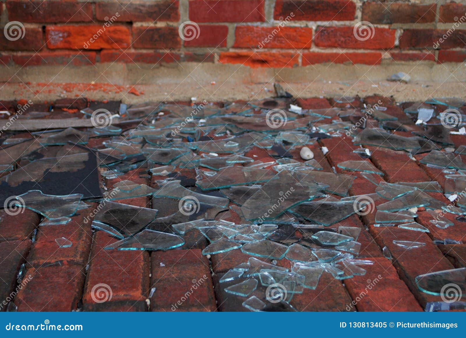 Close Up of a Pile of Broken Glass on a Brick Walkway Stock Image