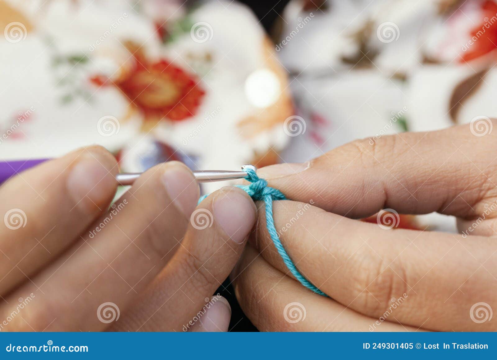 close-up point of view of a woman's fingers crocheting with the number 3 needle and green yarn