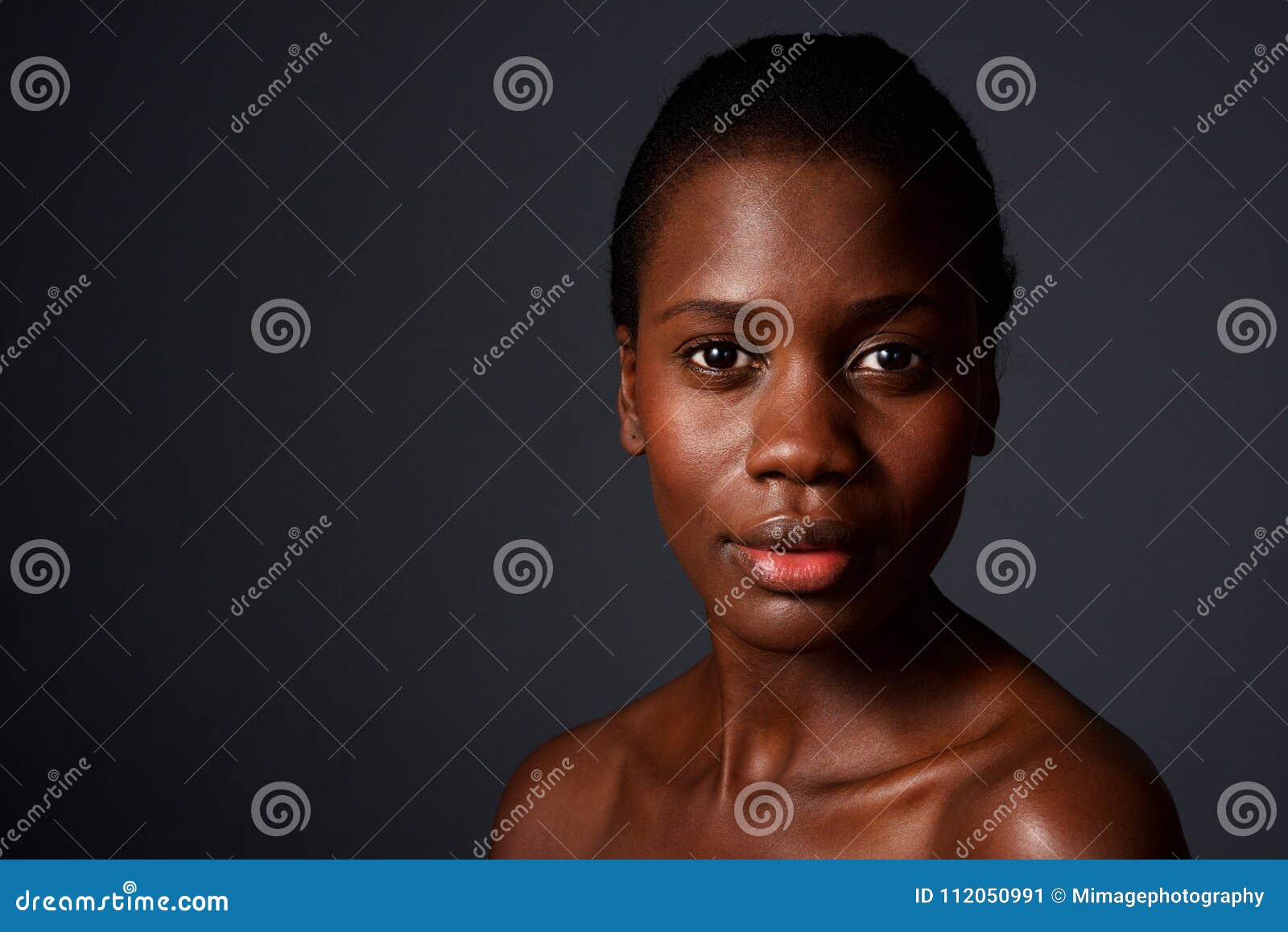 close up beautiful african woman looking at camera with naked shoulders